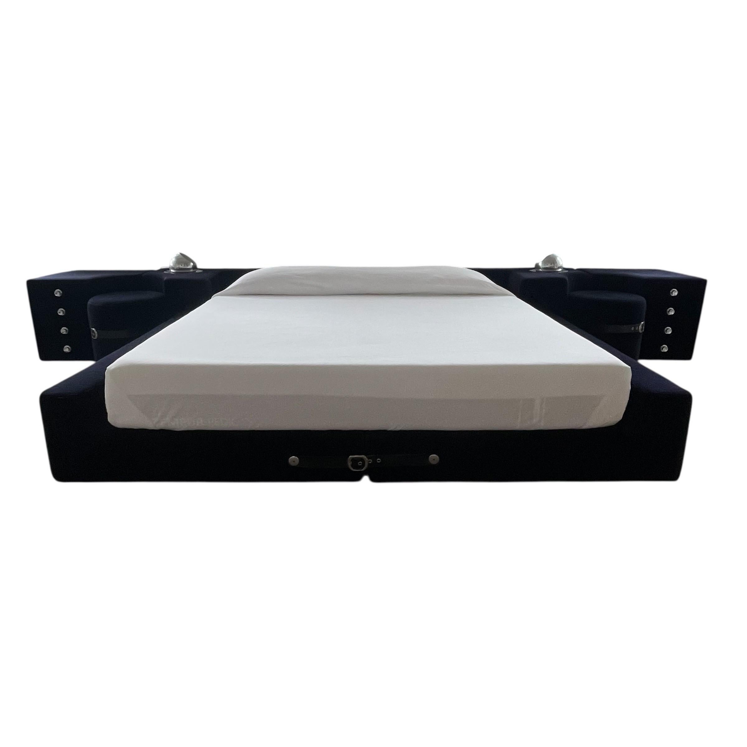 Rare Original Tucroma king size bed rendered in an original Ink colored (blue-black) velvet with black saddle leather straps and chrome buckles, two integrated four drawer nightstands with chrome hardware, two stool or ottomans, and two dimmable and