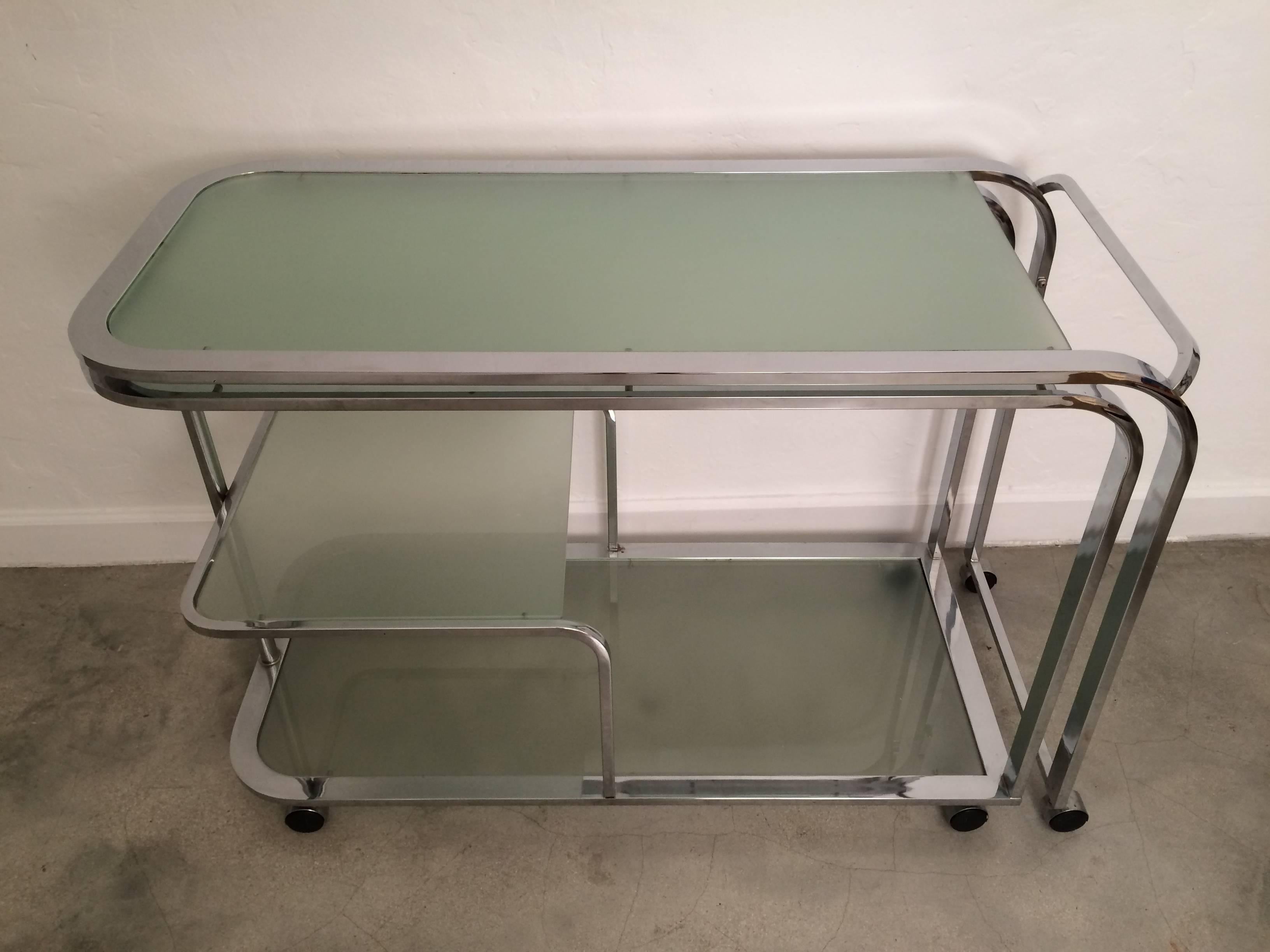 Polished chrome and green glass swivel bar cart or writing table desk by Design Institute of America. Cart expands to 87
