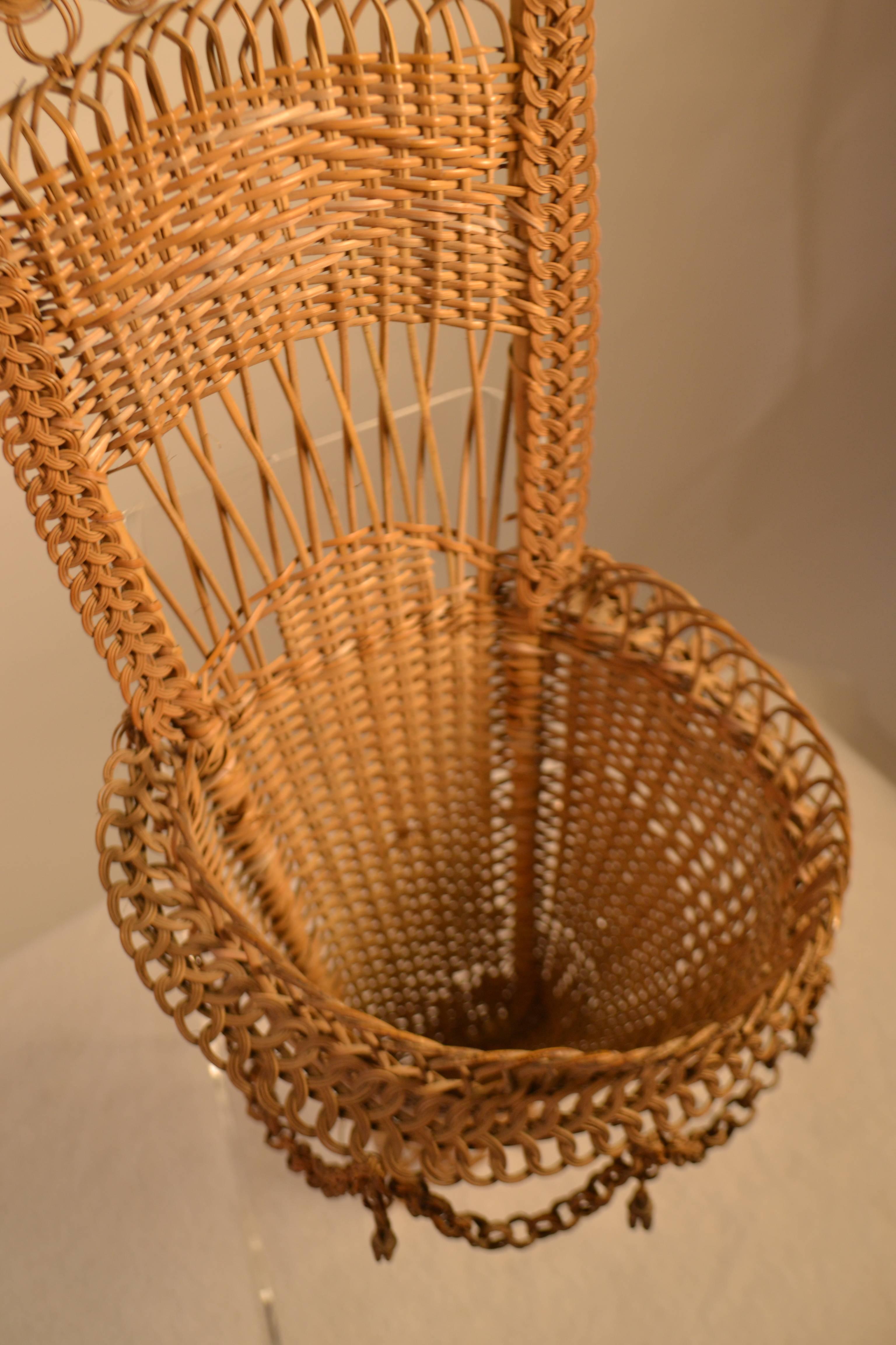 Panier de travail en osier fait à la main avec des boucles de chaîne et des glands. Le fond du panier est usé et déchiré.