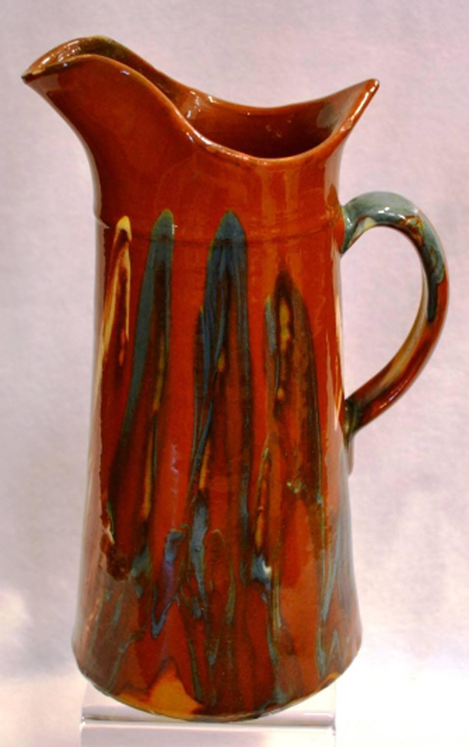 Turn of the century glazed pitcher with dripped and tapered blue painted motif with wide lip for pouring. Possibly Jaspe. Once a common piece of pottery used daily in French kitchens, these earthenware jugs have become showcase pieces sought by