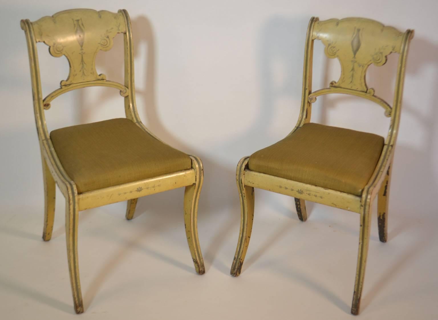Ensemble de quatre petites chaises peintes avec une peinture de couleur moutarde.