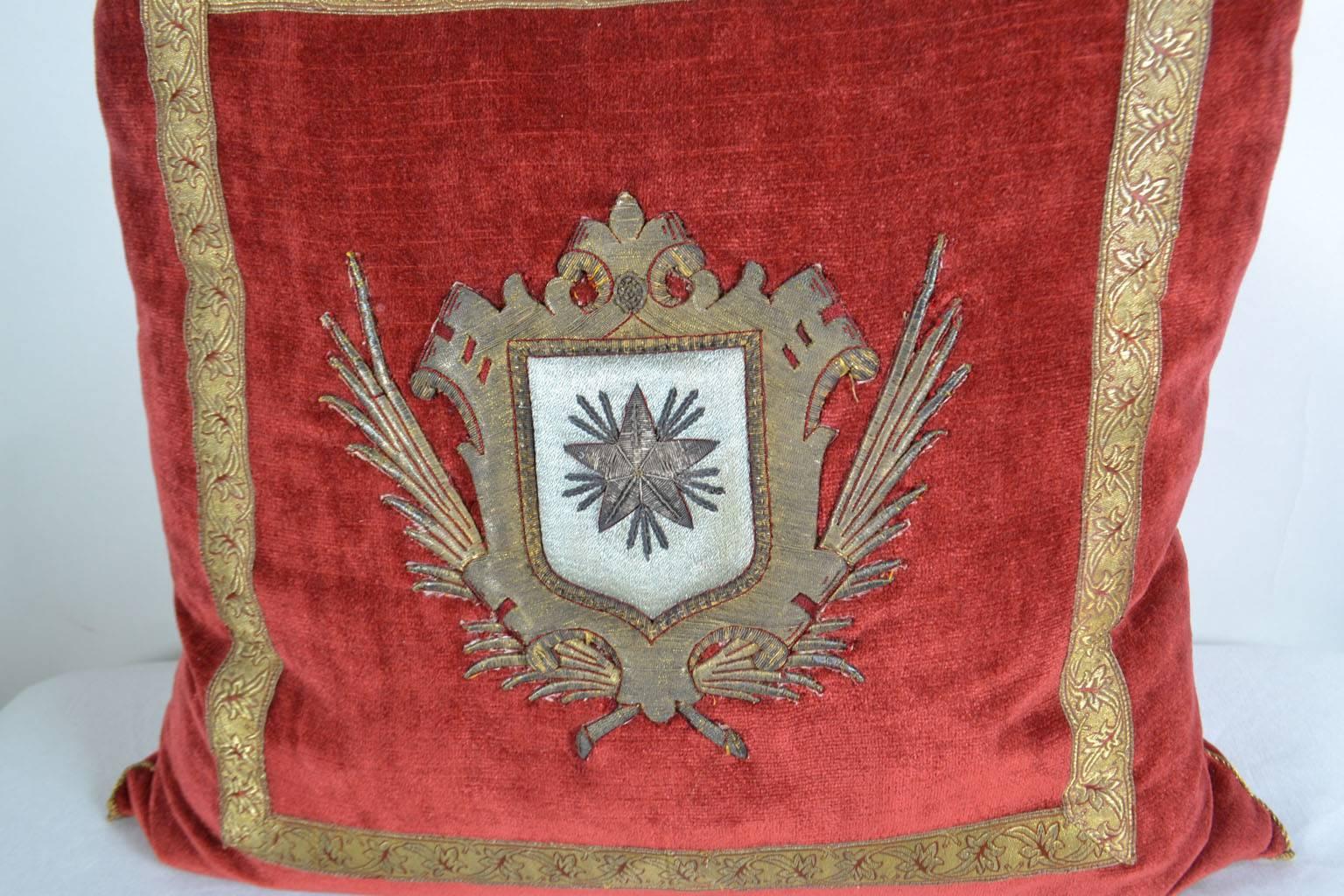 18th c. Italian crest on wine red velvet framed with vintage red and gold galon. Hand trimmed with tiny gold metallic military cording from Europe. Down filled. (THE MEWS).