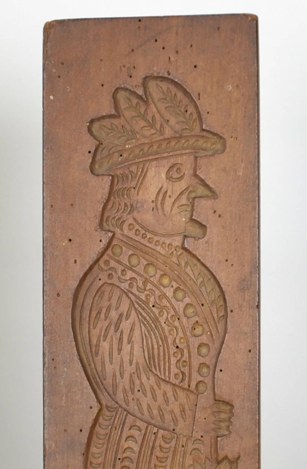 Wooden gingerbread mold (man with feathers in hat and umbrella), signed.