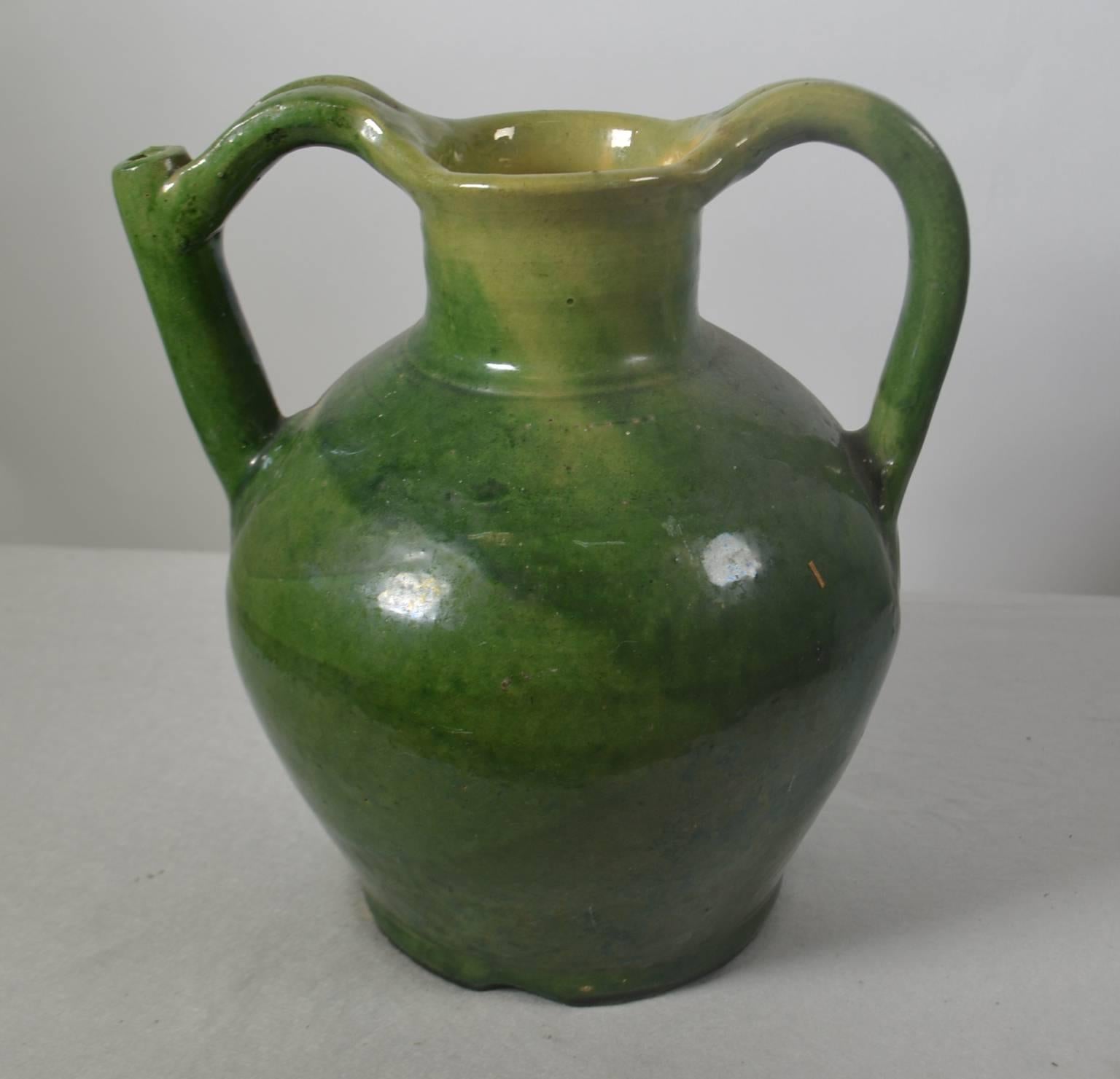 Terracotta jug with spout in handle. Green glaze, circa 1860. Once a common piece of pottery used daily in French kitchens, these earthenware jugs have become showcase pieces sought by designers and collectors. These beautiful vessels offer a depth