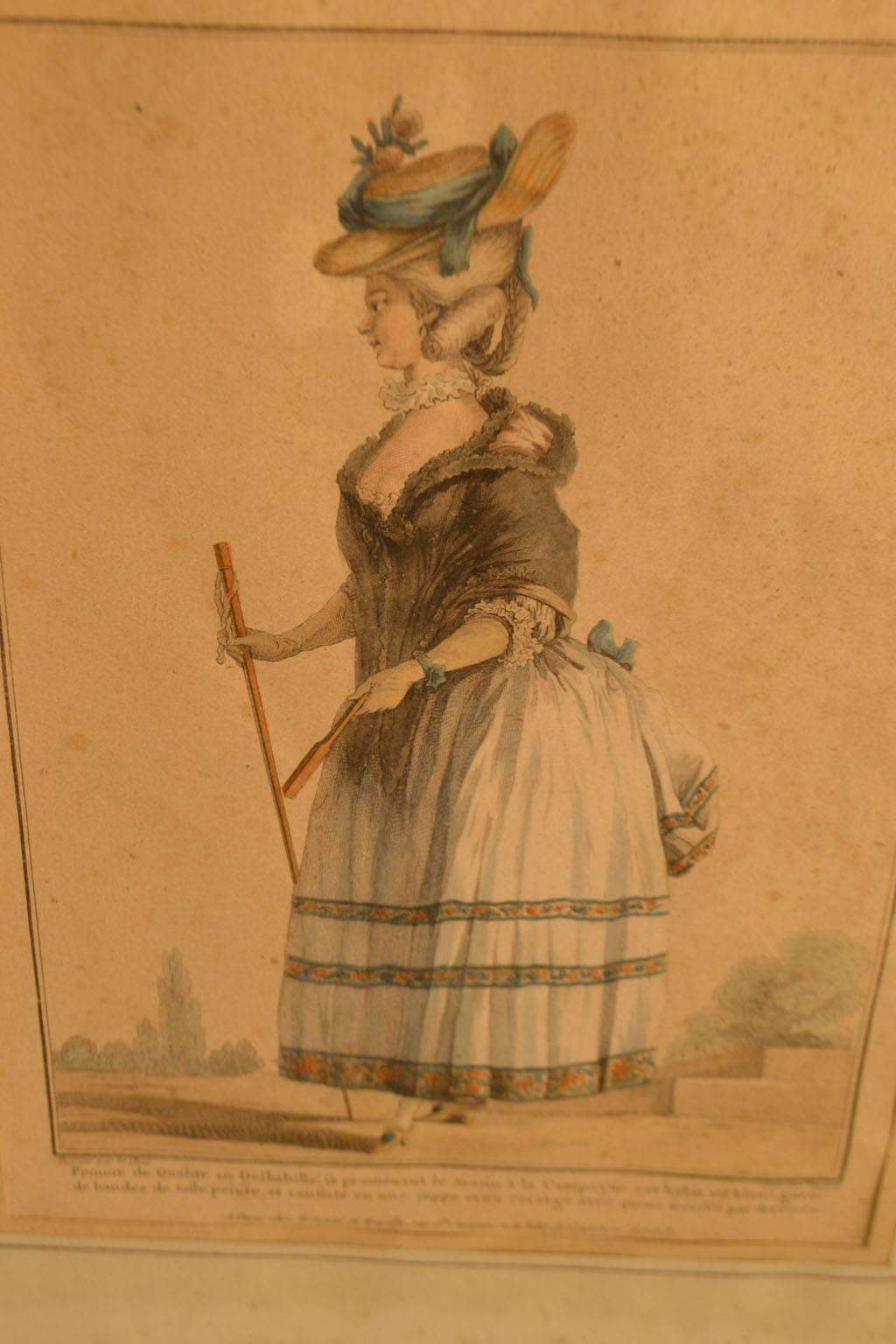 18th century framed fashion engraving of a woman with a plume feather hat with fan and a walking stick.