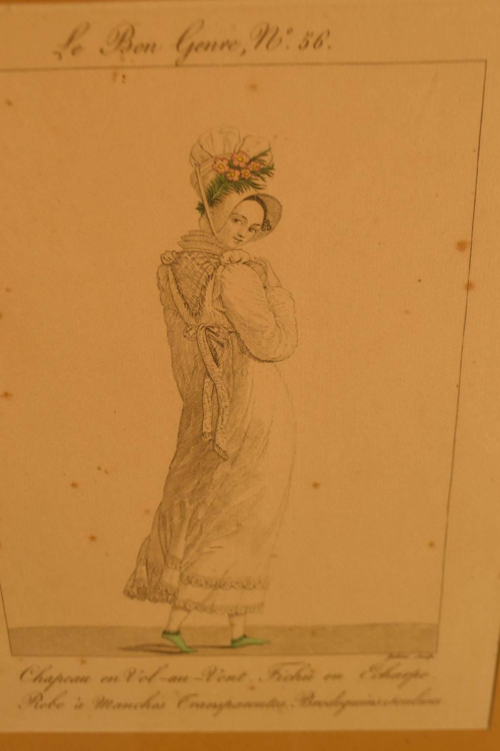 18th century gold framed fashion engraving of a woman in a dress and bonnet and sea green shoes. Some pitting to the engraving.