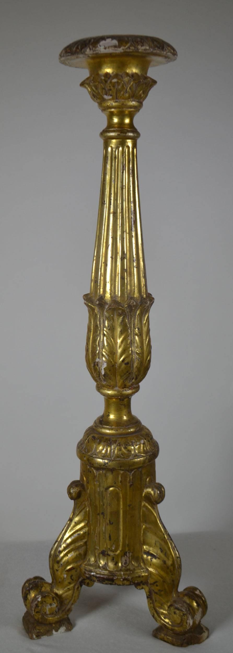 Louis XVI period giltwood candlestick with a fluted column ending in acanthus leaves above scroll feet. Some chipping at the top and bottom of piece.