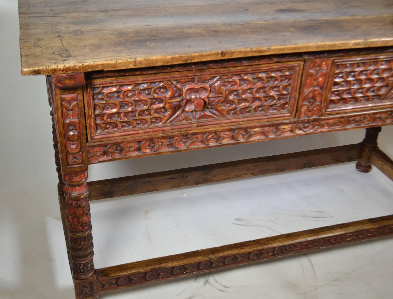 18th century polychrome, Spanish colonial console table, with two drawers, turned legs, fish tail carving surrounding typical Spanish carved rosettes, a beautiful planked top, resting on a box stretcher and ball feet; Peru.