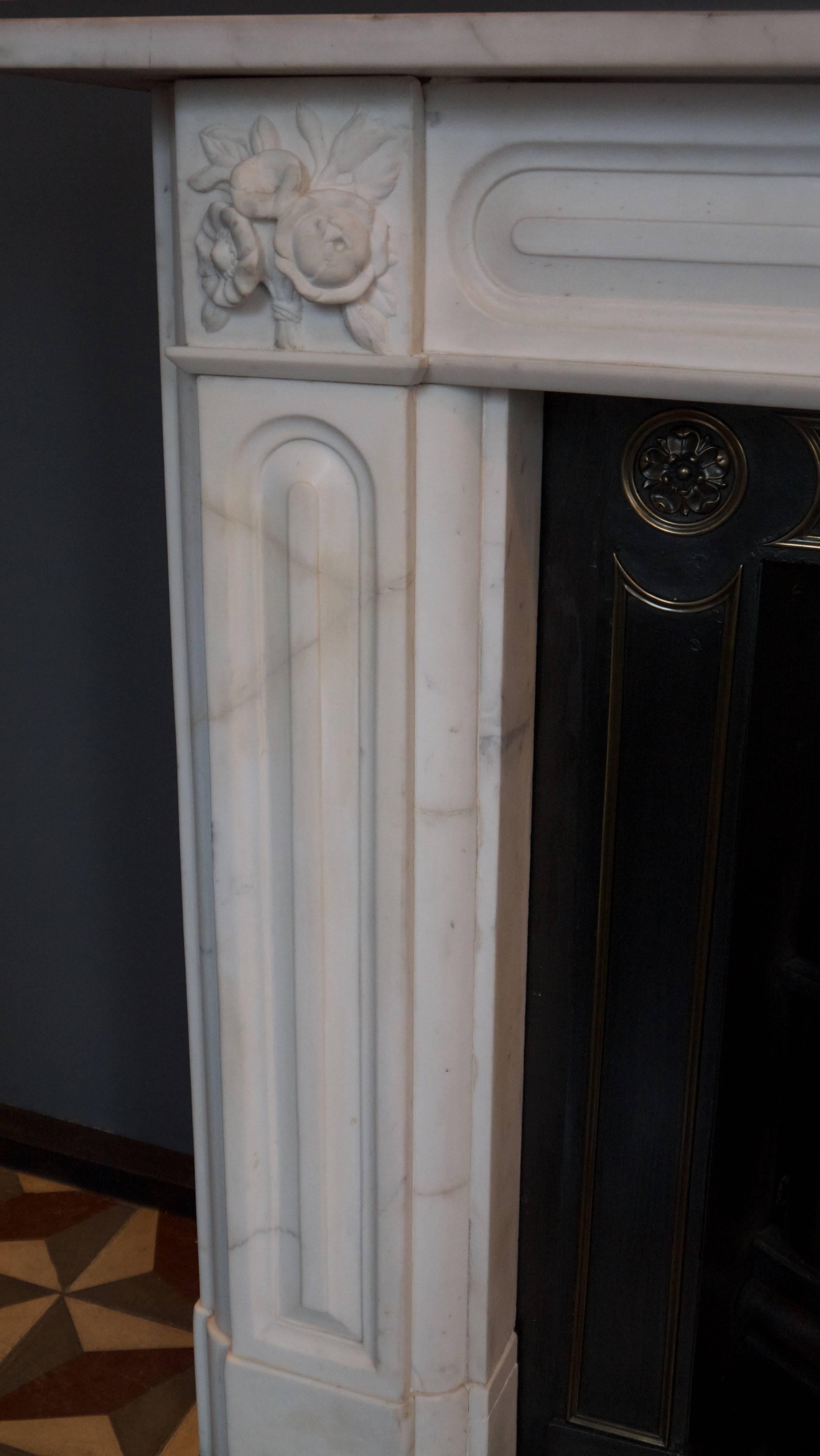 Antique Regency Statuary white marble Fireplace with intricately carved bouquets on the corner blocks and panelled legs and frieze. Measures: Opening 38