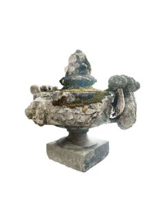 19th-century stone pediment with Corinthian scrollwork, and an Artichoke Finial