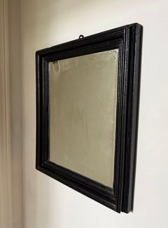 An early 19th century black Mirror with Original Distressed Glass