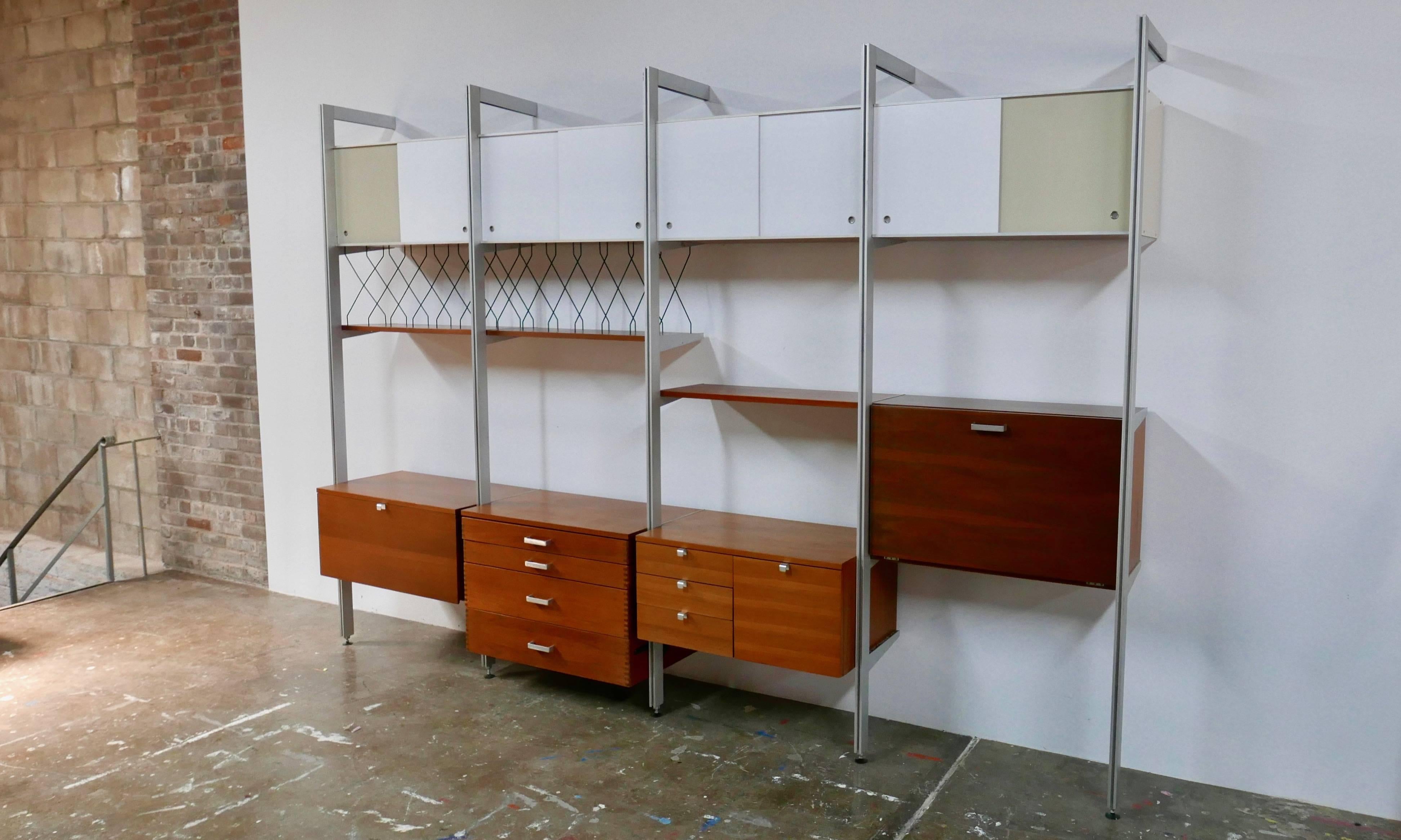 Four section storage unit designed by George Nelson for Herman Miller. Sliding doors along the top offer cabinet storage. The lower cabinets offer drawers and a hanging file along with a drop down desk. Each section is 32" wide. The shelf depth