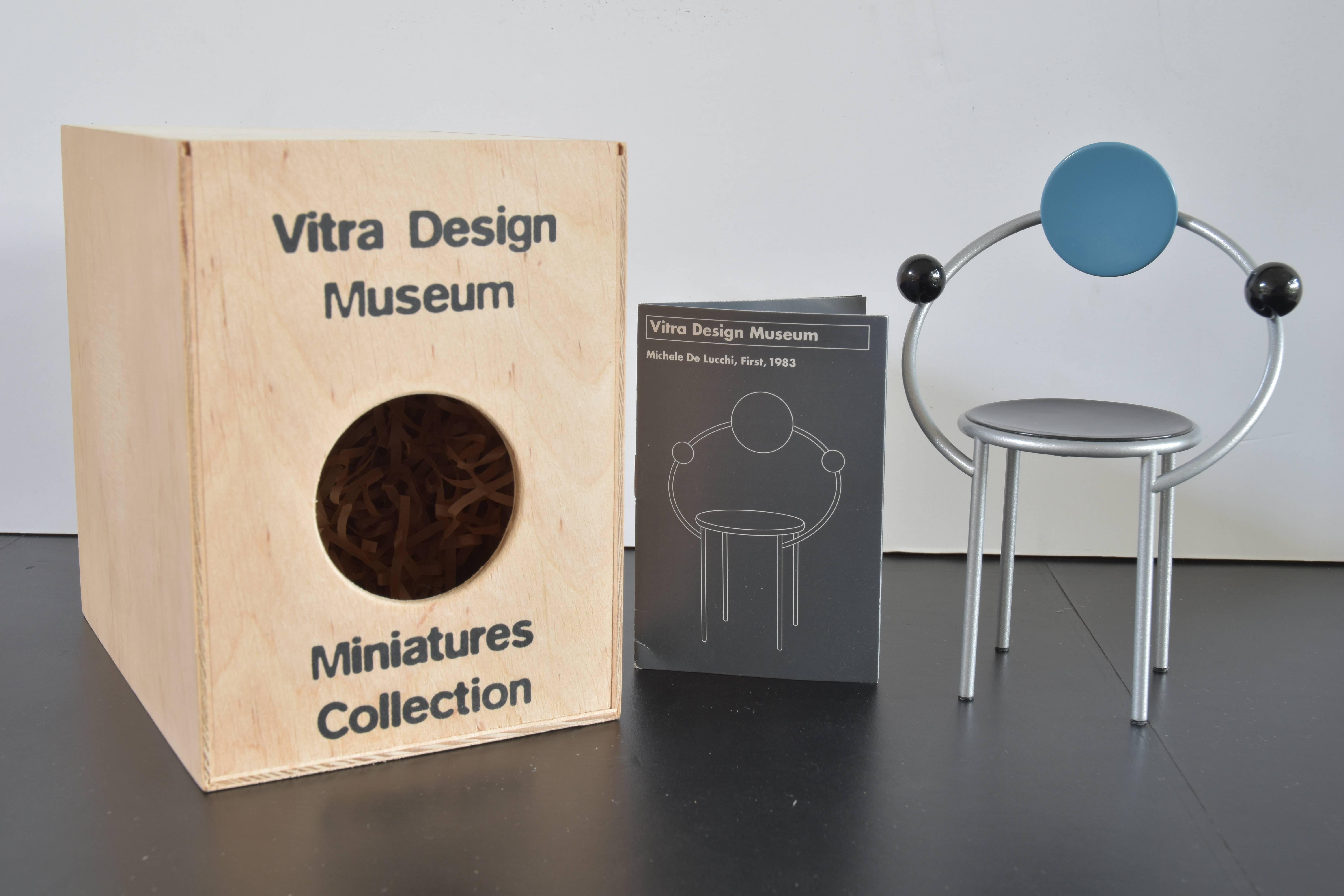 From the Vitra Design Museum collection of miniature models, a Michele De Lucchi, First Model chair originally produced in 1983.

Included are the miniature model and historical narrative of the maker and the piece.