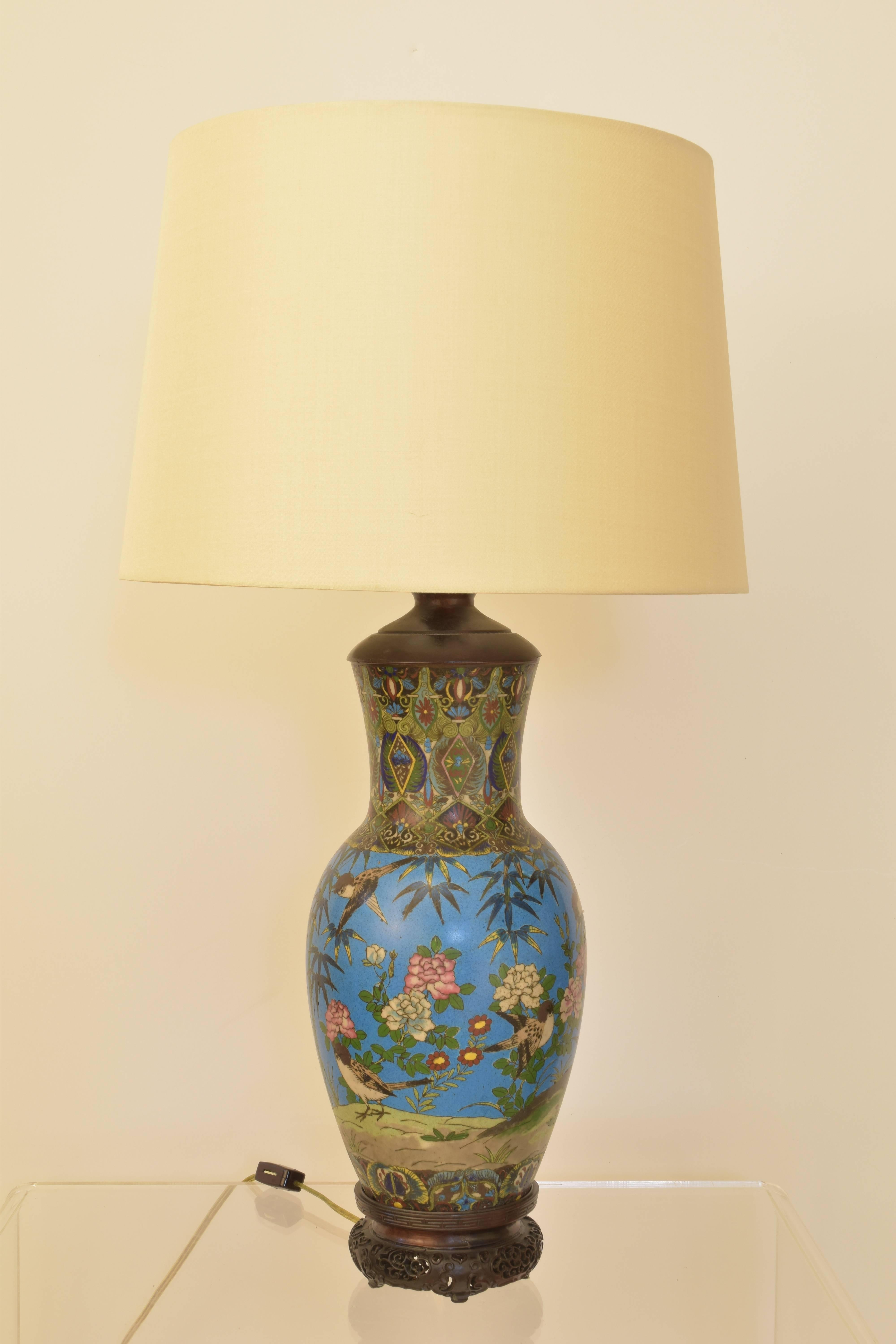 An early cloisonné vase wired as a lamp in the 20th century on a vintage base with an amber finial. The lamp is exceptional with vivid shades of blue and bird and floral decoration throughout.

Lamp measures 26.5