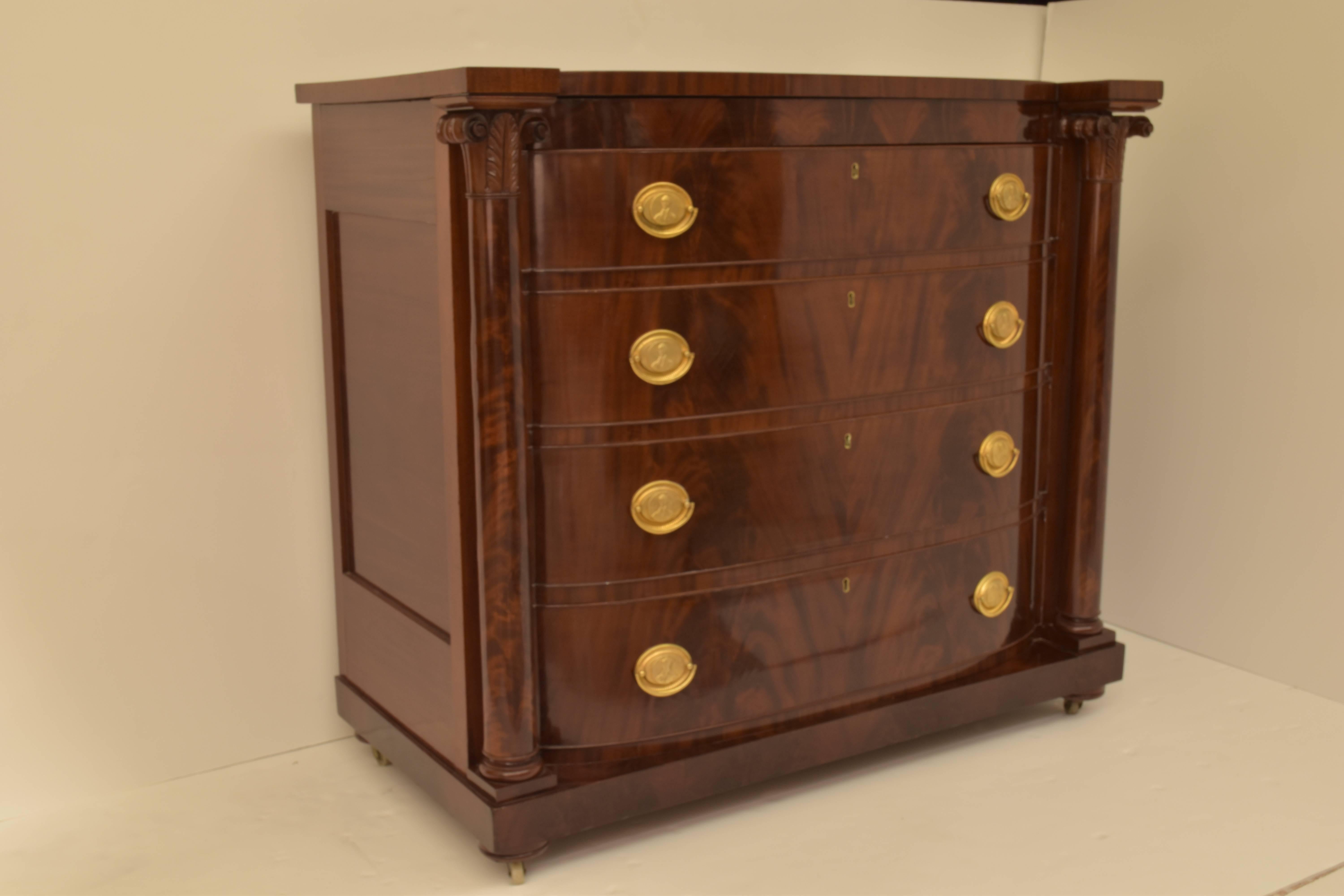 A mahogany bow front chest of drawers with period George Washington brasses. The chest features four drawers.