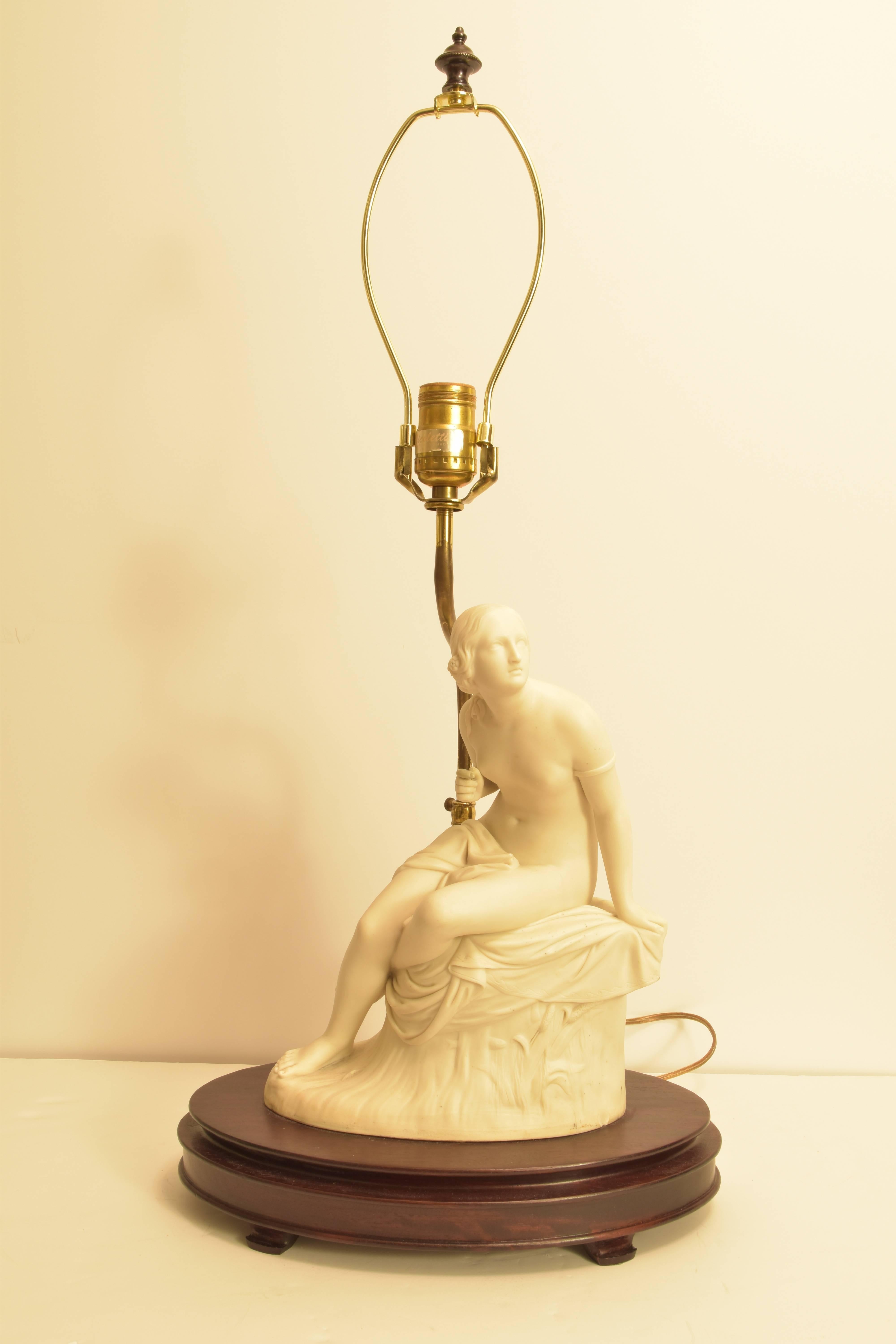Porcelain lamp with a female figure mounted on a wooden base. 

Lamp measures 17