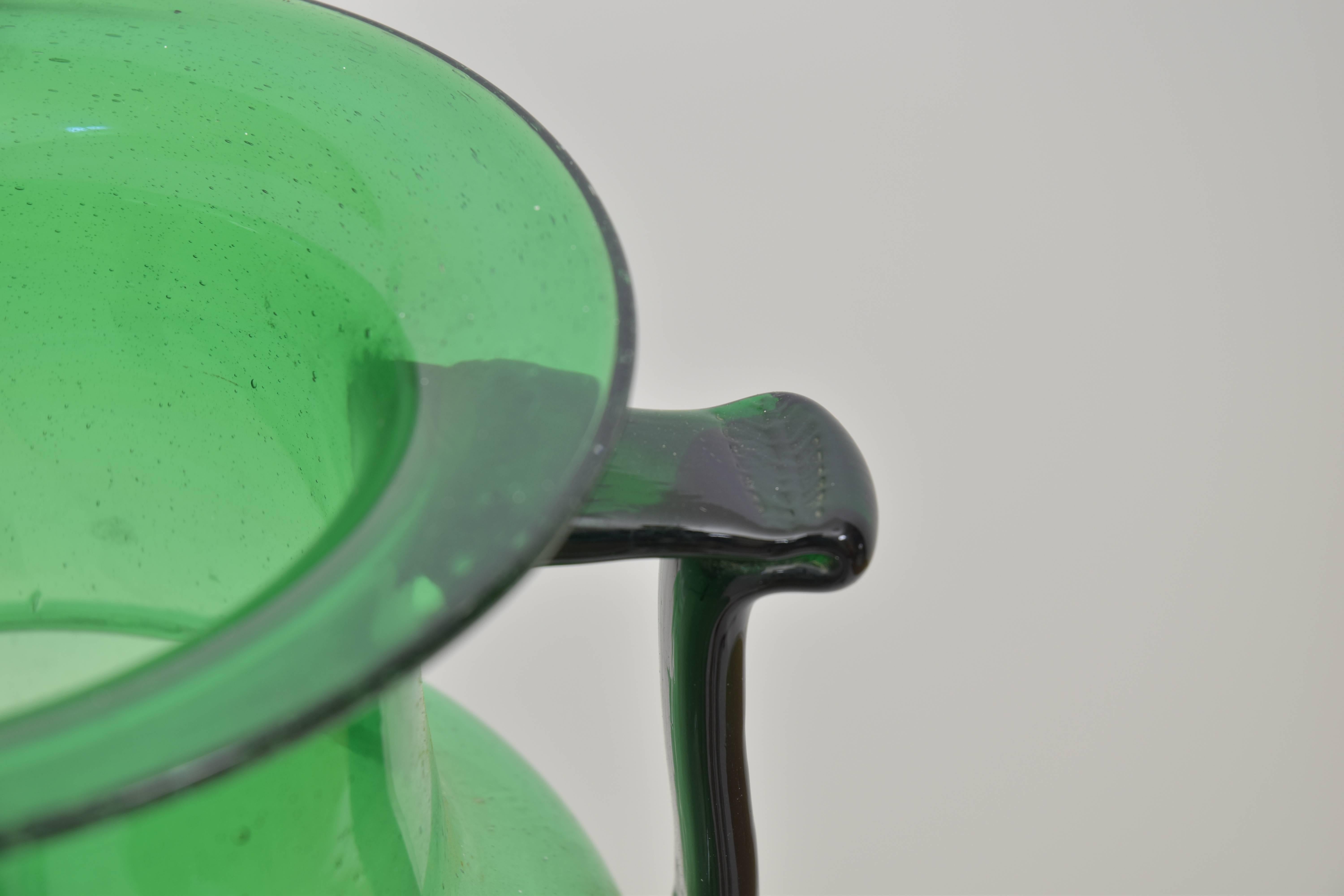 A very large-scale and well-proportioned dark emerald green glass vase. Handblown with handle accents on the sides.