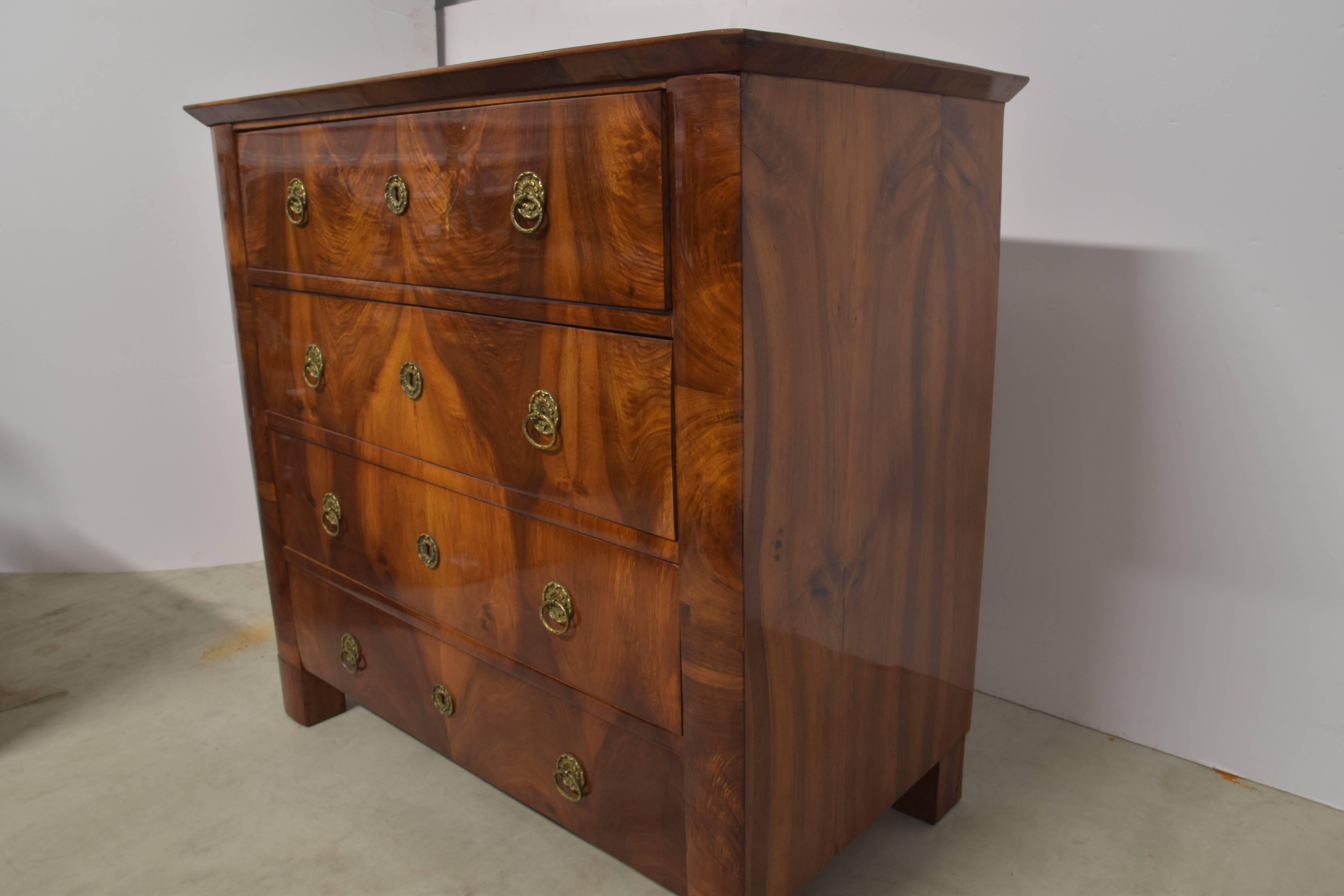 19th century Biedermeier commode in excellent condition with a beautiful French polish finish.  Each of the four drawers is highlighted with beautifully book matched fronts with original brasses.
