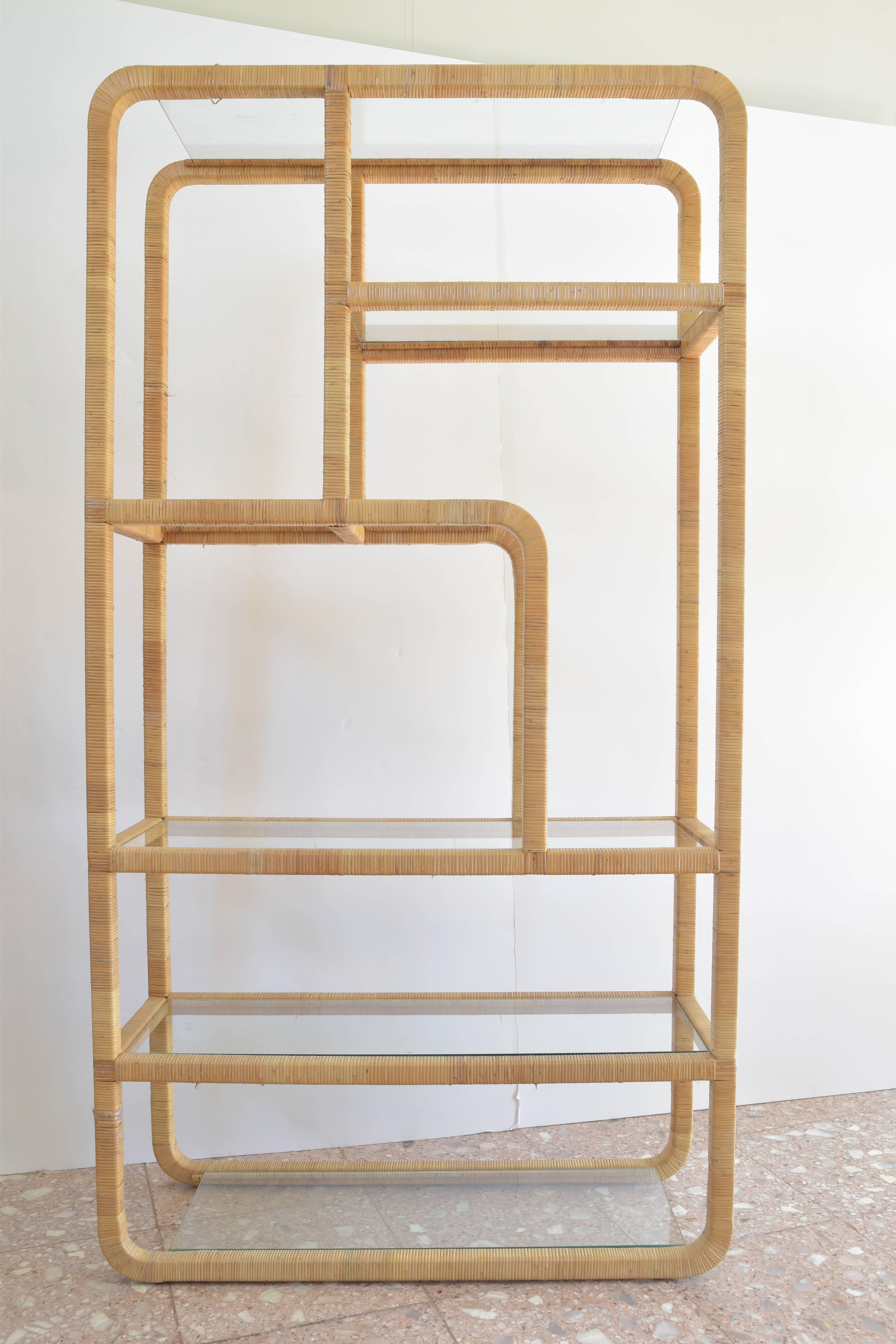 Mid-Century Modern rattan wrapped etagere with five glass shelves of varied length.
