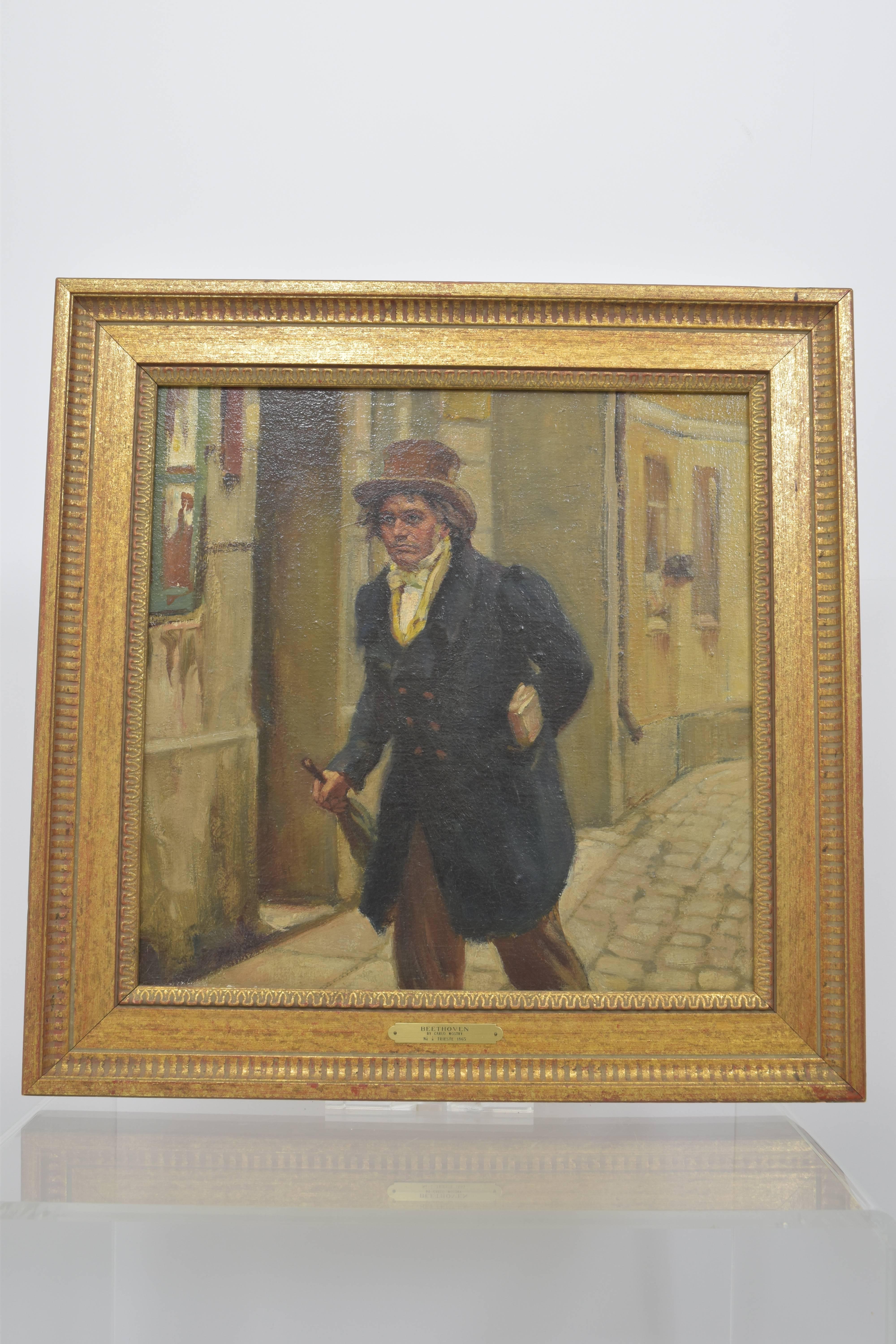 Oil on canvas painting depicting a somber Beethoven walking on a cobblestone street at the foreground with a woman peering out a window in the background. In a giltwood frame with plaque that reads 