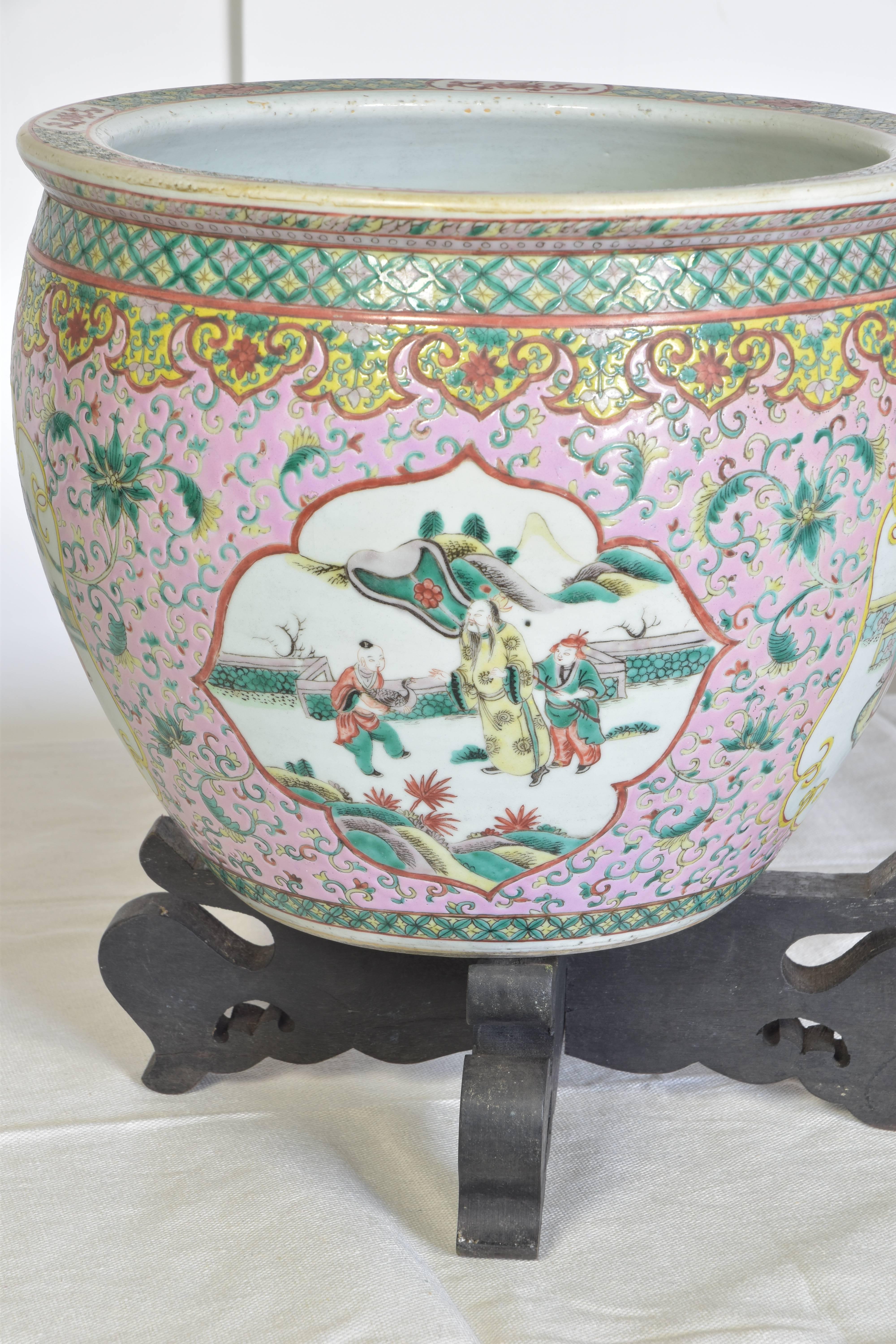 Large hand-painted Chinese jardiniere in pale aqua, rose, white and yellow hues. The piece features four medallions with hand-painted figures that feature delicately detailed faces. The piece is hand-painted on the interior with goldfish. Listing