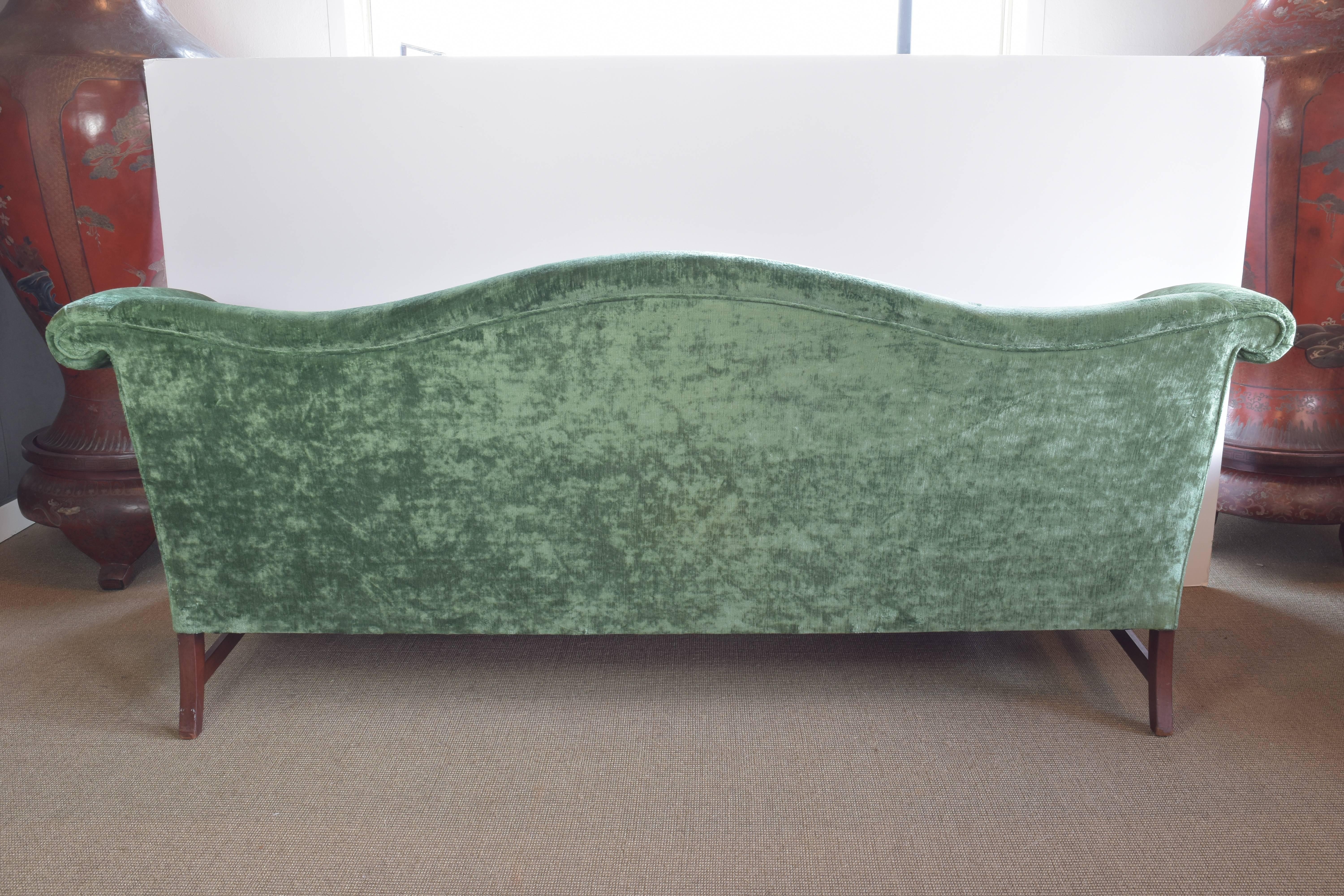 Beautiful green velvet camelback sofa with mahogany base and updated with new upholstery in an Old World Weavers green linen velvet.
     
