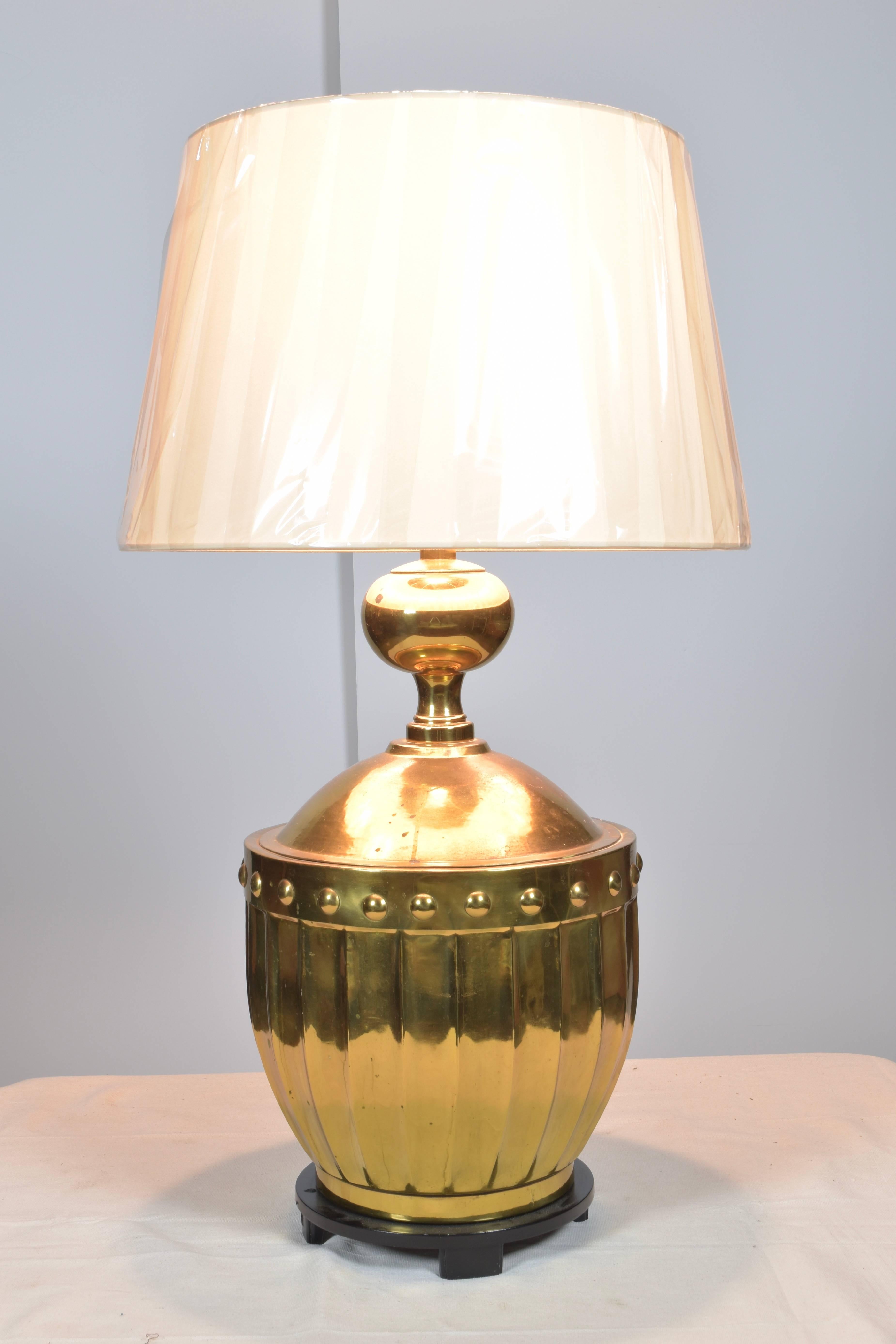 Gorgeous pair of brass Stiffel lamps on wooden stands. These striking urn form lamps have great presence and are encircled with button detailing.