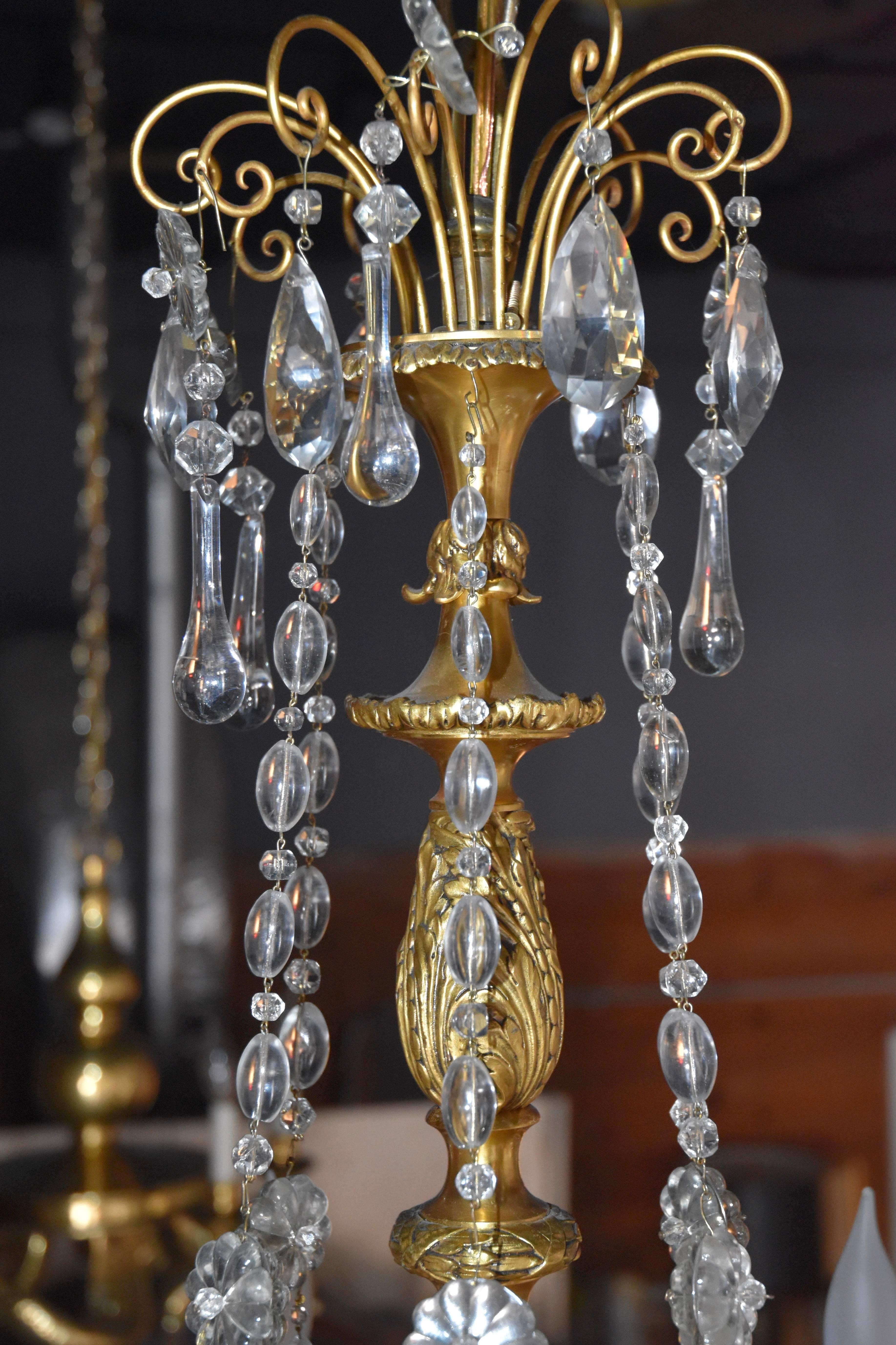 An exceptional bronze chandelier with faceted prisms and intricate bronze detailing throughout.