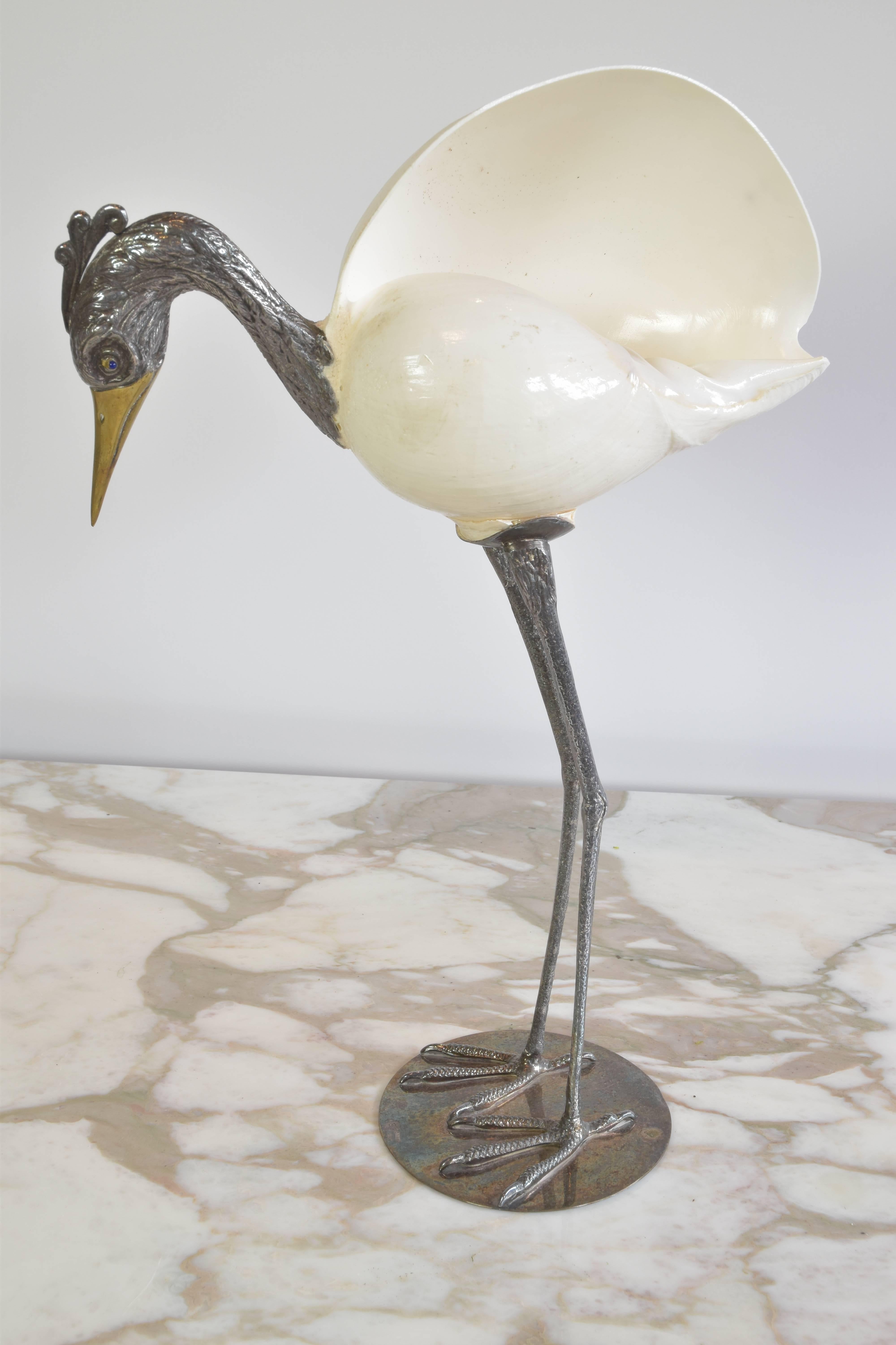 Gabriella Binazzi bird sculpture with a natural shell body. A striking piece with silvered metal legs and head and gold beak with blue natural stone eyes.