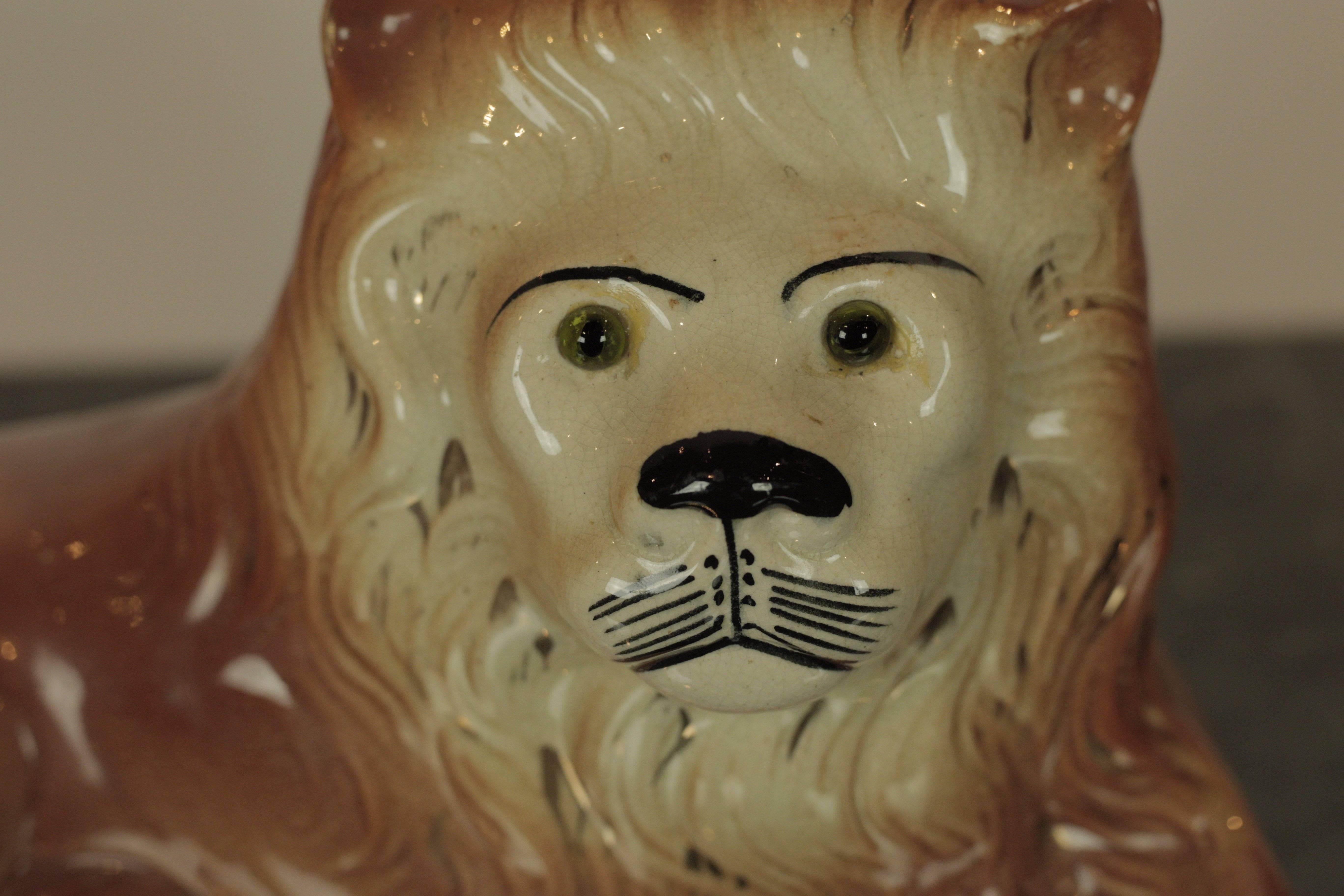 Charming Staffordshire lion in repose with green glass eyes.