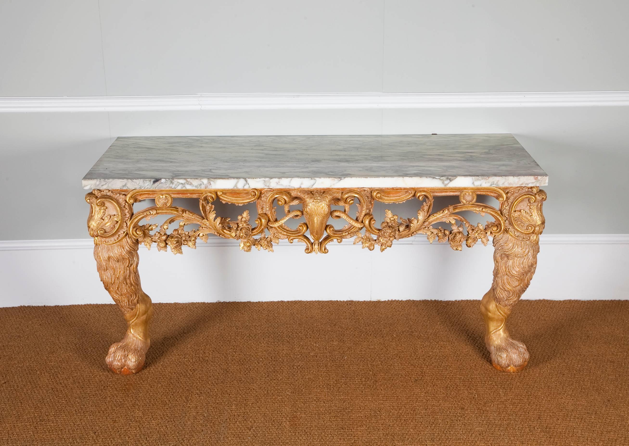 A superbly carved mid-18th century giltwood console table. The later breche violette marble top above a frieze of c-scrolls and acanthus with a central ram's head mask, supported by bold animalistic carved legs. In the manner of Matthias
