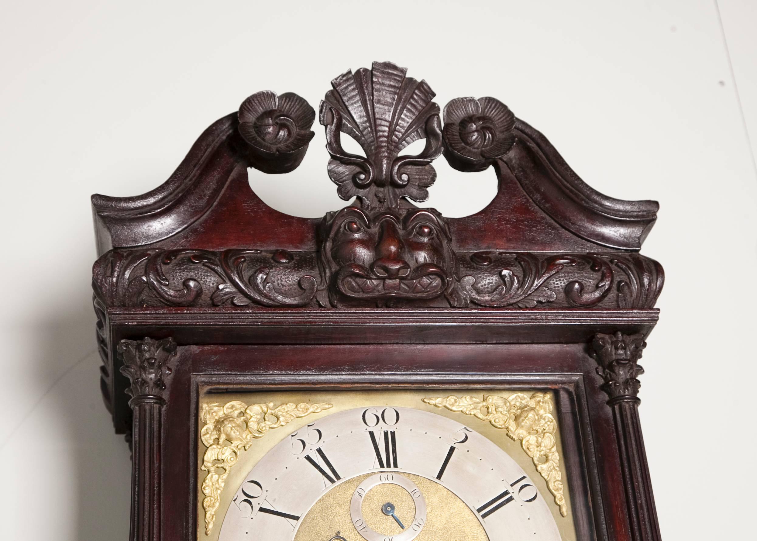 A good Irish long case clock by Thomas Blundel. The case with a swan neck top curved with an Irish mask on a cushion moulding of acanthus with carved rosettes, supported by fluted columns and a long central door, retaining good original color and