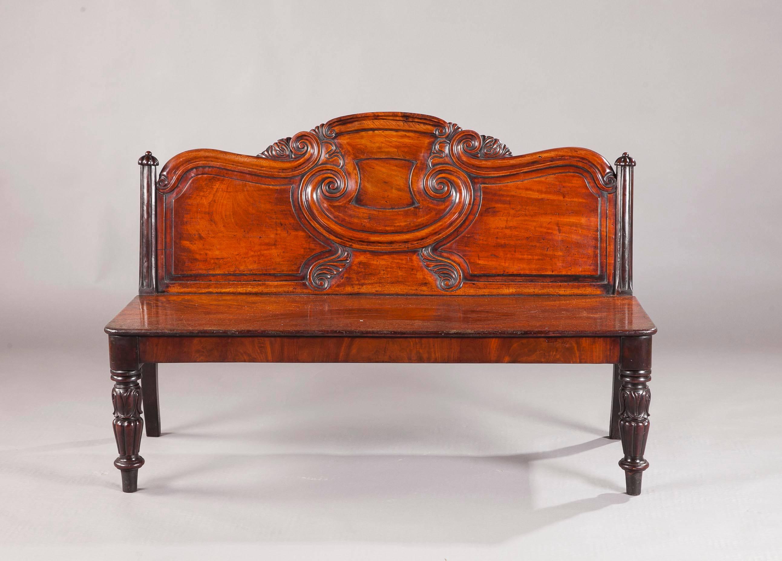 An Irish George IV mahogany hall bench, the well carved and reeded back above a rectangular seat, resting on turned fluted legs with acanthus carving. Probably made by Gillington Dublin.
 
Footnote, the firm of Gillington where one of Ireland's