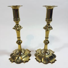Un magnífico par de candelabros ingleses del siglo XVIII, de latón, estilo Reina Ana, con base festoneada