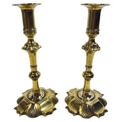 Un magnífico par de candelabros ingleses del siglo XVIII, de latón, estilo Reina Ana, con base festoneada