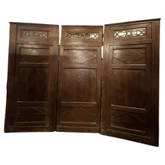 Walnut entrance door with three doors, carved panels and central knocker, italy