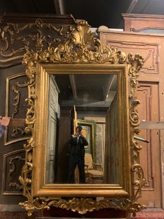 Miroir en bois sculpté et doré, avec une riche corniche, XIXe siècle