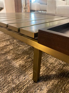 Sculptural coffee table in brushed brass, with a top in oak and marble.