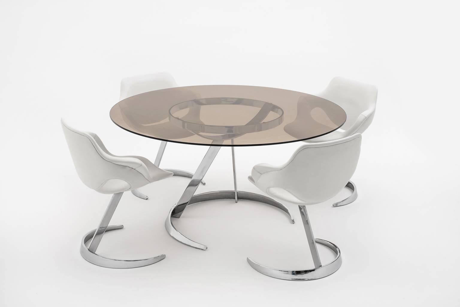 Exclusive table and chairs by Boris Tabacoff for Mobilier Modulaire Moderne, France, 1960s. High and heavy quality chromed solid steel. The chairs are upholstered with the original vinyl which is in perfect condition, the table has a chic smoked