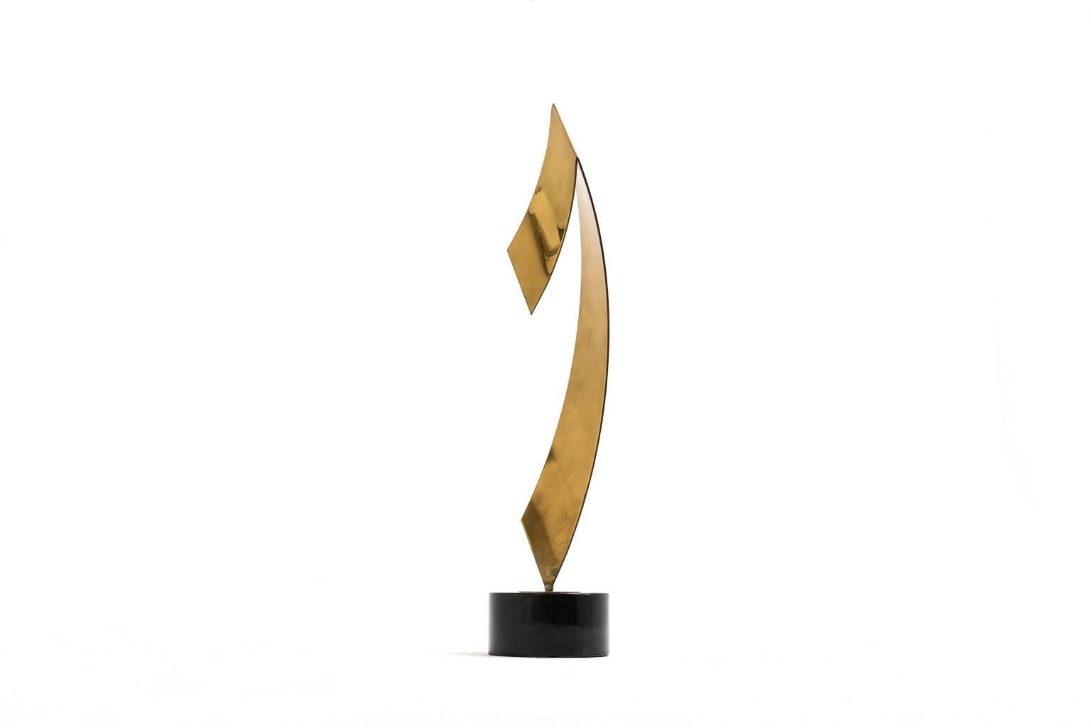 Abstract brass sculpture by Yvonne Tindas, France, 1970s. Tindas is best know for her jewelry designs, her sculptures are much more rare. The sculpture has a beautiful sharp but elegant shape and stands on a black marble base. The brass shows a