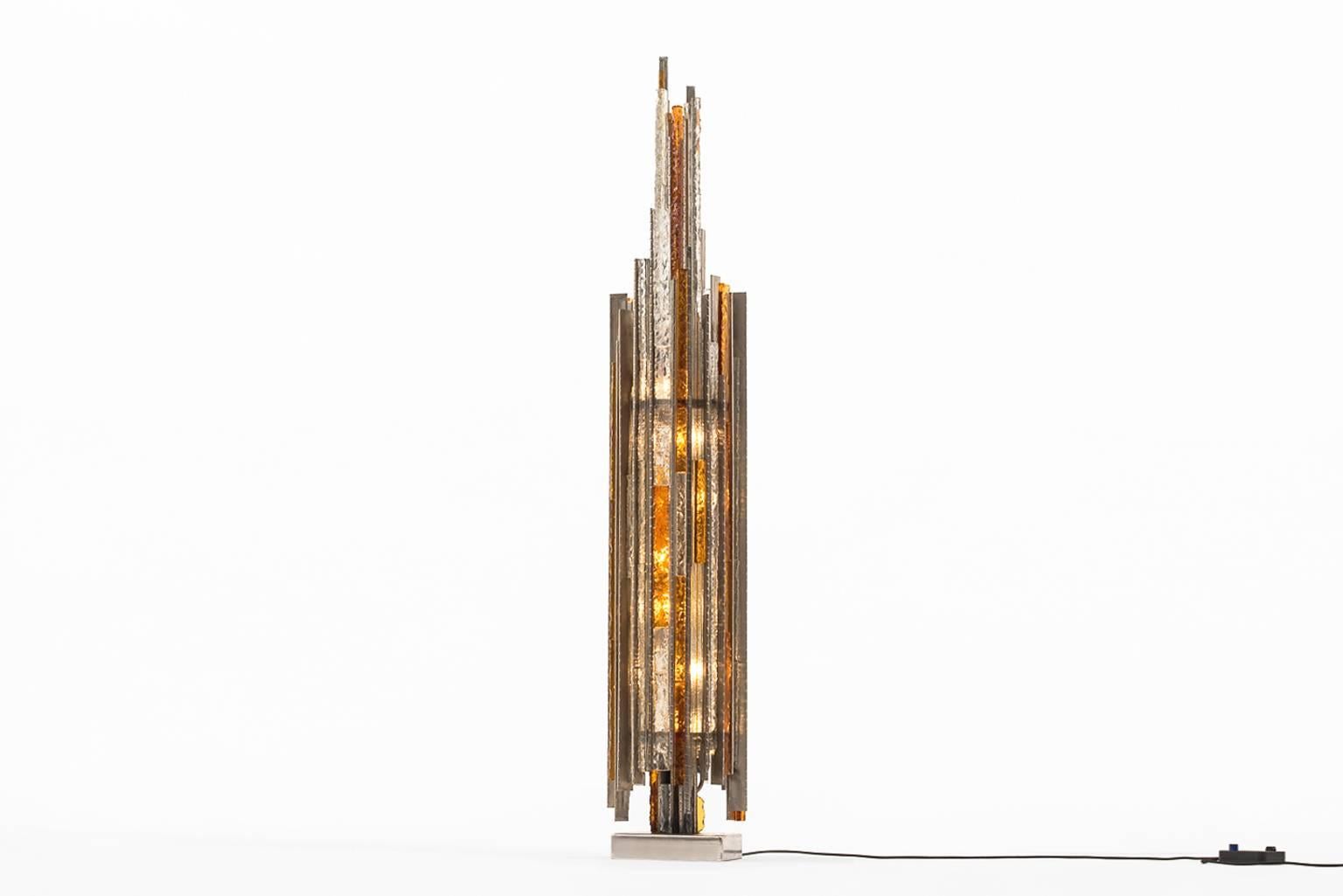 Exceptional floor lamp by Poliarte, Italy 1970s. Made from clear and amber colored Murano glass, all handcrafted with each their own unique structure.
The lamp is demountable; two separate parts are seamlessly hanged to the metal frame. Provided