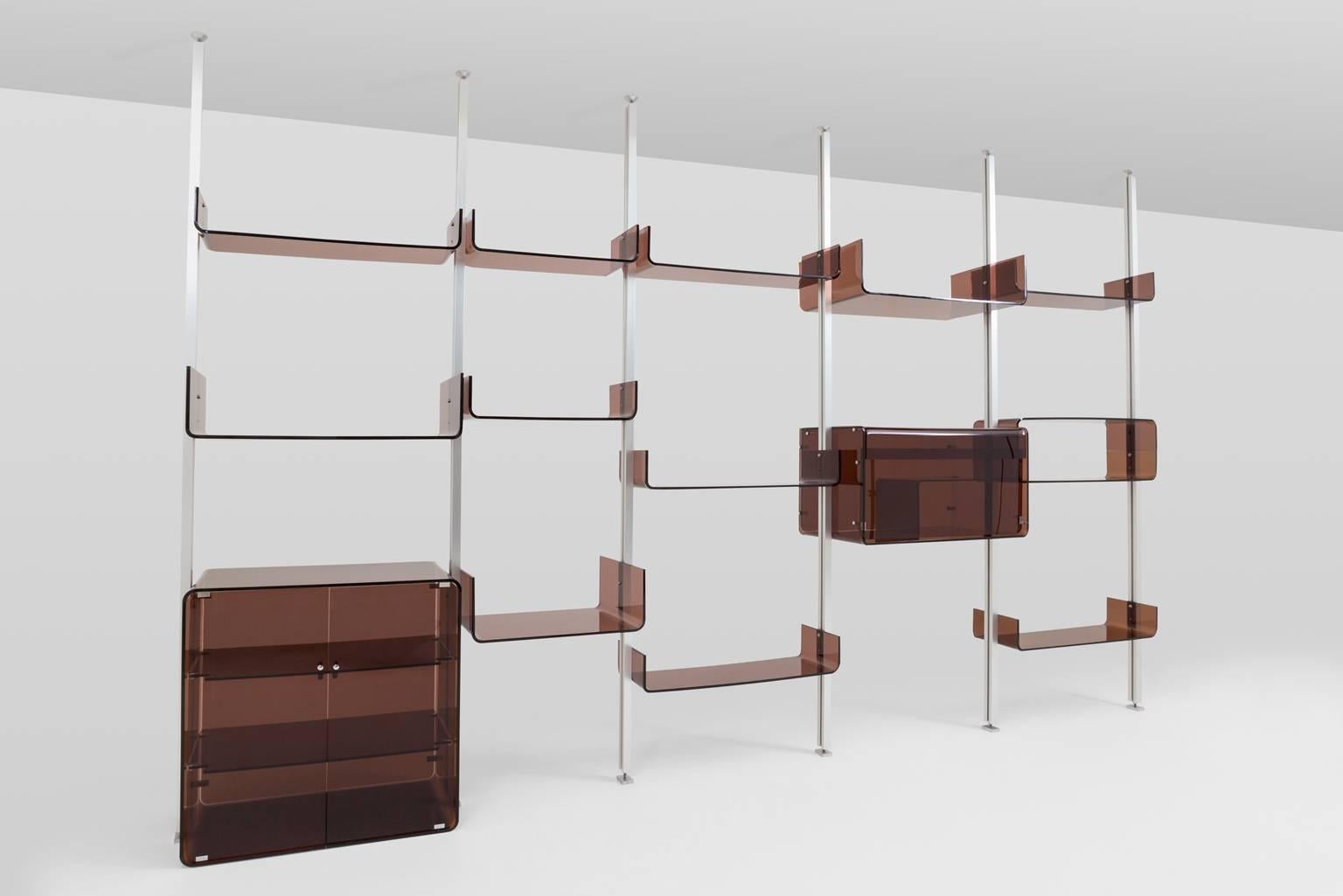 Architectonic shelving system by Michel Ducaroy for Roche Bobois, France, 1970s. The system is composed of several shelves and two cabinets made from smoked red-pink transparent Lucite (plexiglass) which can be ordened between the brushed aluminum