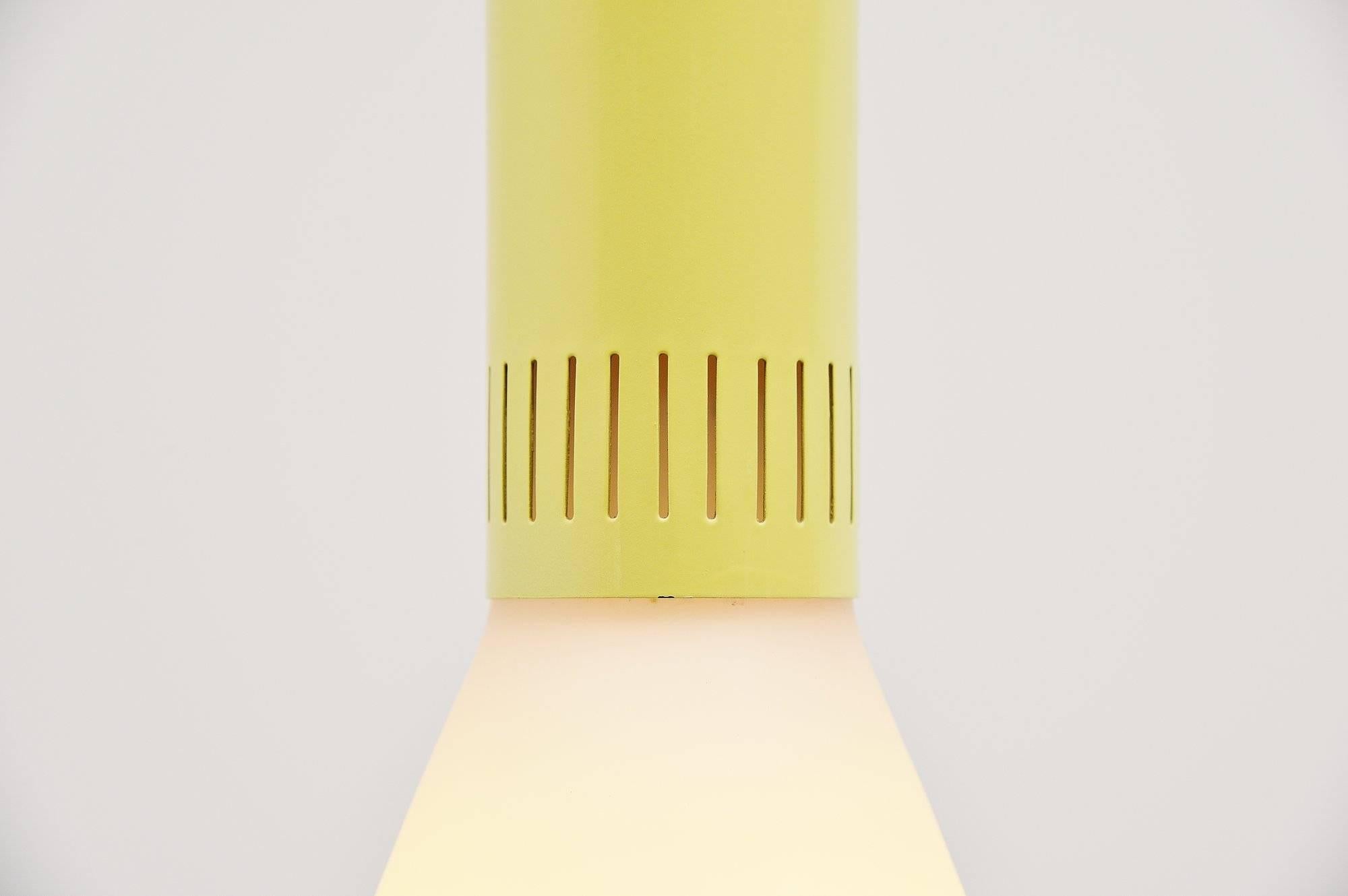 Nice pendant lamp designed and made by Stilnovo, Italy, 1960. This is for a very nice modernist shaped pendant lamp with a yellow lacquered metal shade holder and a large white opaline glass diffuser shade. The lamp has a funny plexi piece that