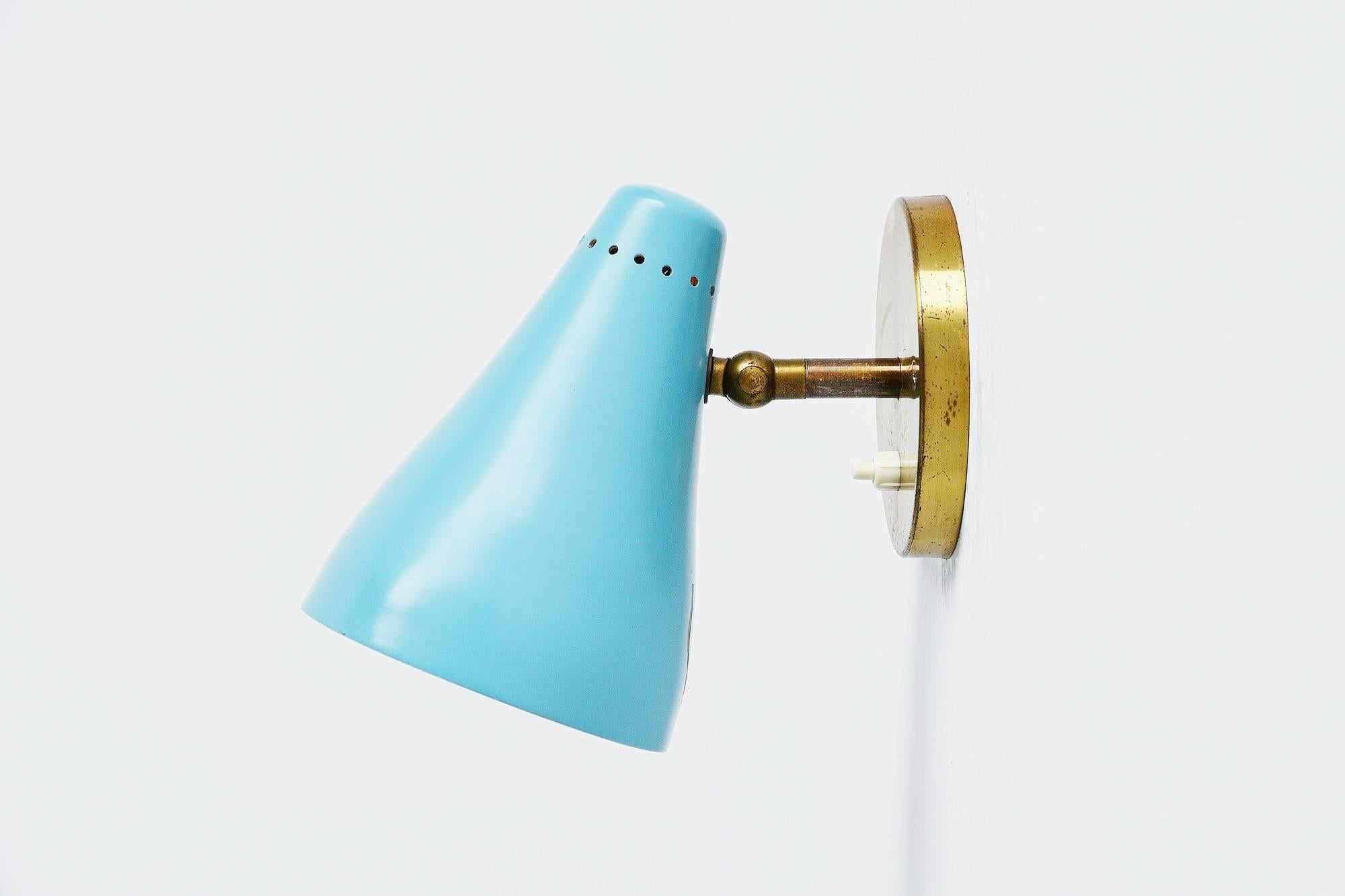 Early sconce model 16c designed by Gino Sarfatti, manufactured by Arteluce, Italy, 1948-1950. This early wall lamp has a brass wall plate and a blue painted shade with die cut dot pattern at the top of the shade. The lamp is unmarked but written
