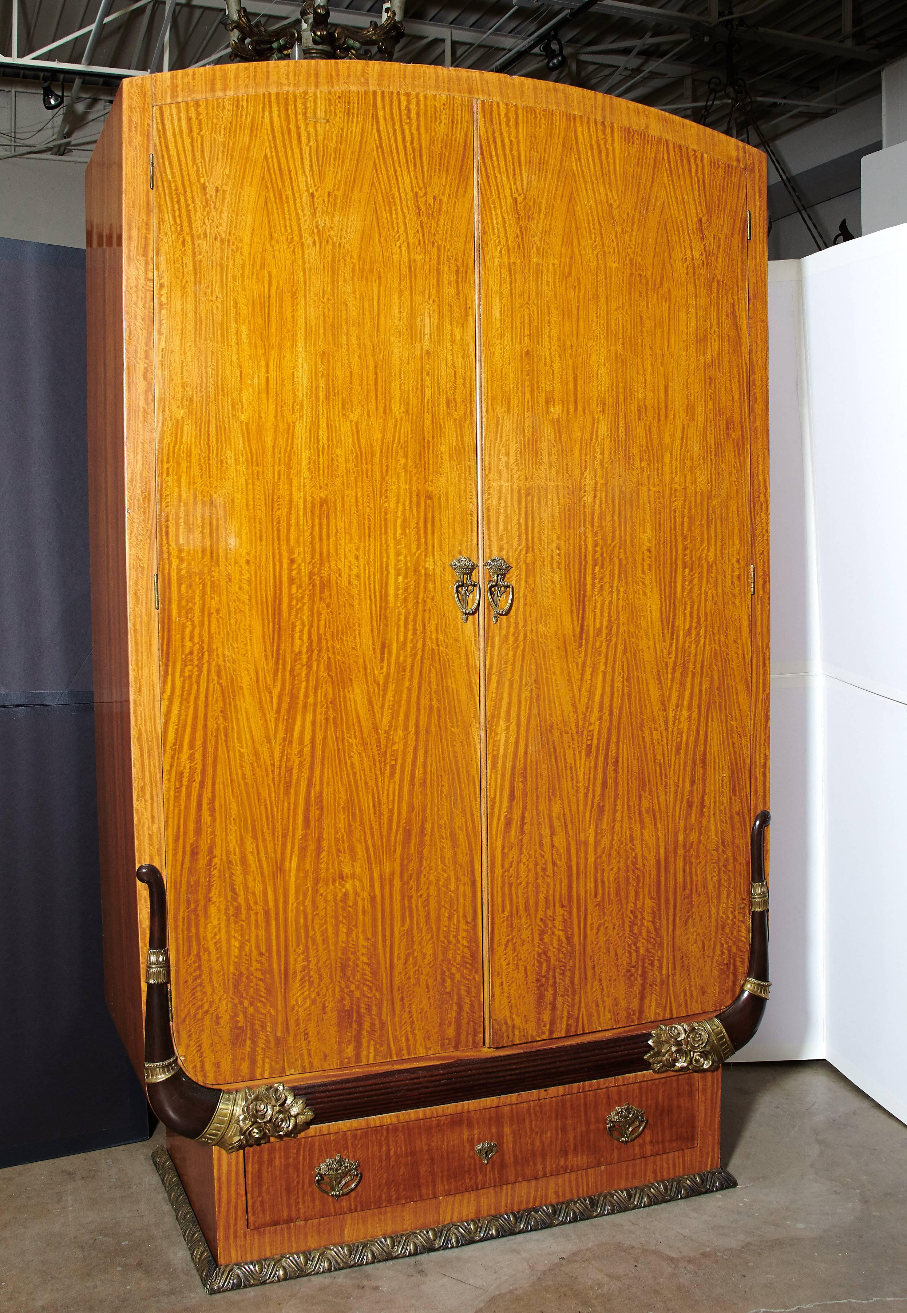 Outstanding pair of Art Deco cabinets or armoires in the manner of Sue et Mare. These examples of fine cabinet making exhibit mortise and tenon construction throughout utilizing satinwood, mahogany and ebony. The beautifully cast and chased bronze