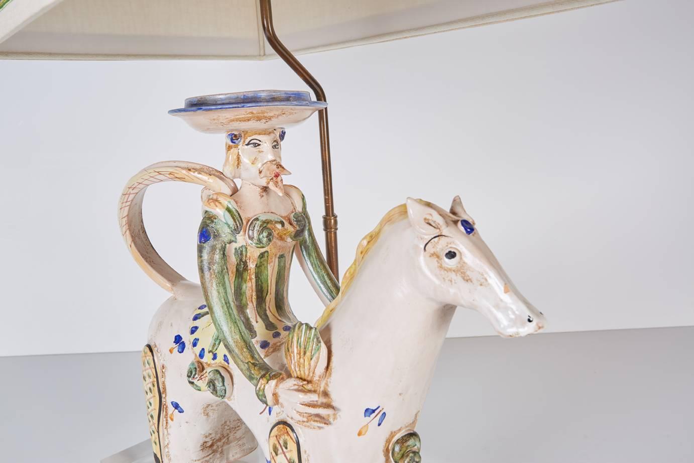 Italian Mid-Century Modern ceramic horse with rider mounted as a lamp on a custom Lucite base and with a custom shade in natural linen trimmed in blue ribbon and silver cord.