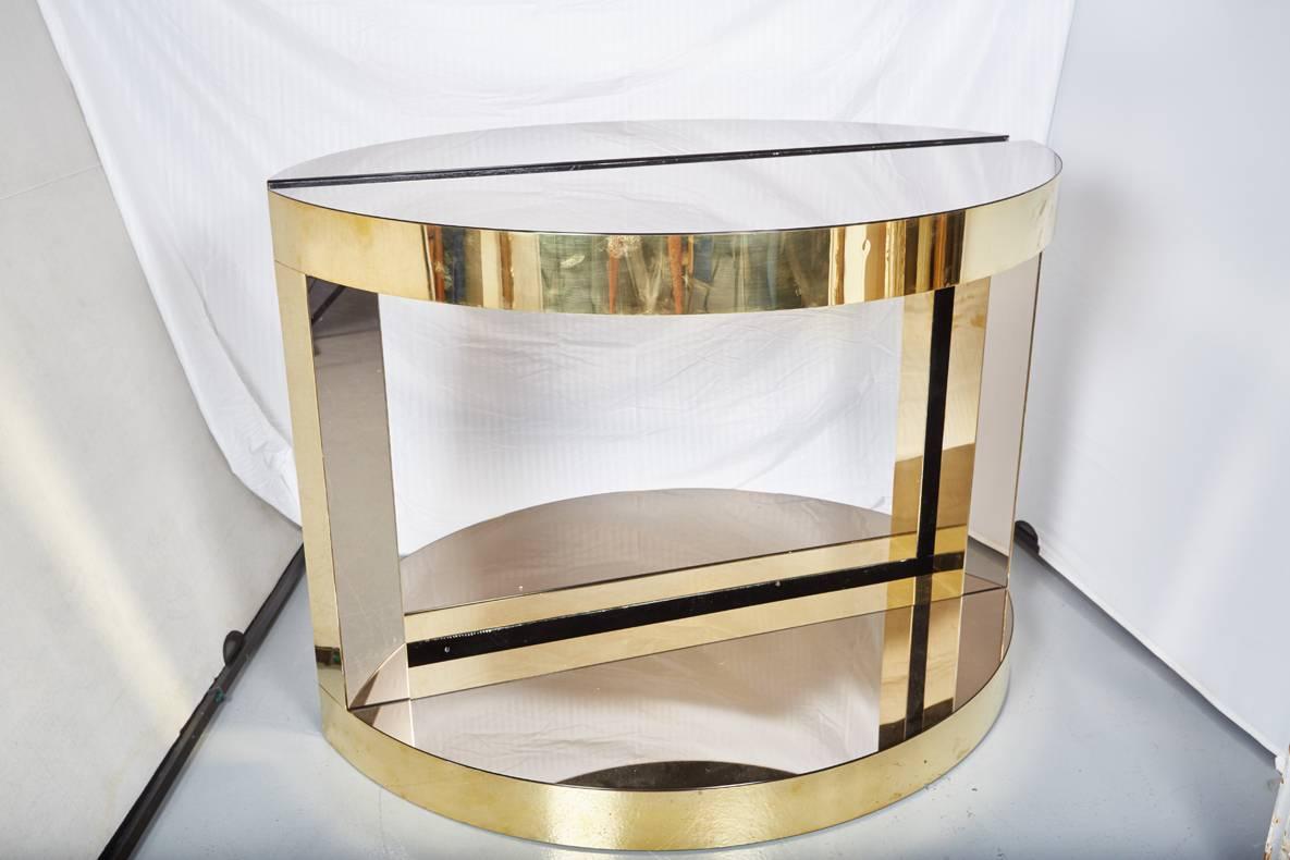 Pair of midcentury Italian brass and mirrored glass demilune consoles by Sandro Petti for L Angolo Metallarte. The heavy gauge solid brass is fitted over a wood core. The mirrow glass has a smoked finish which contrasts handsomely with the polished