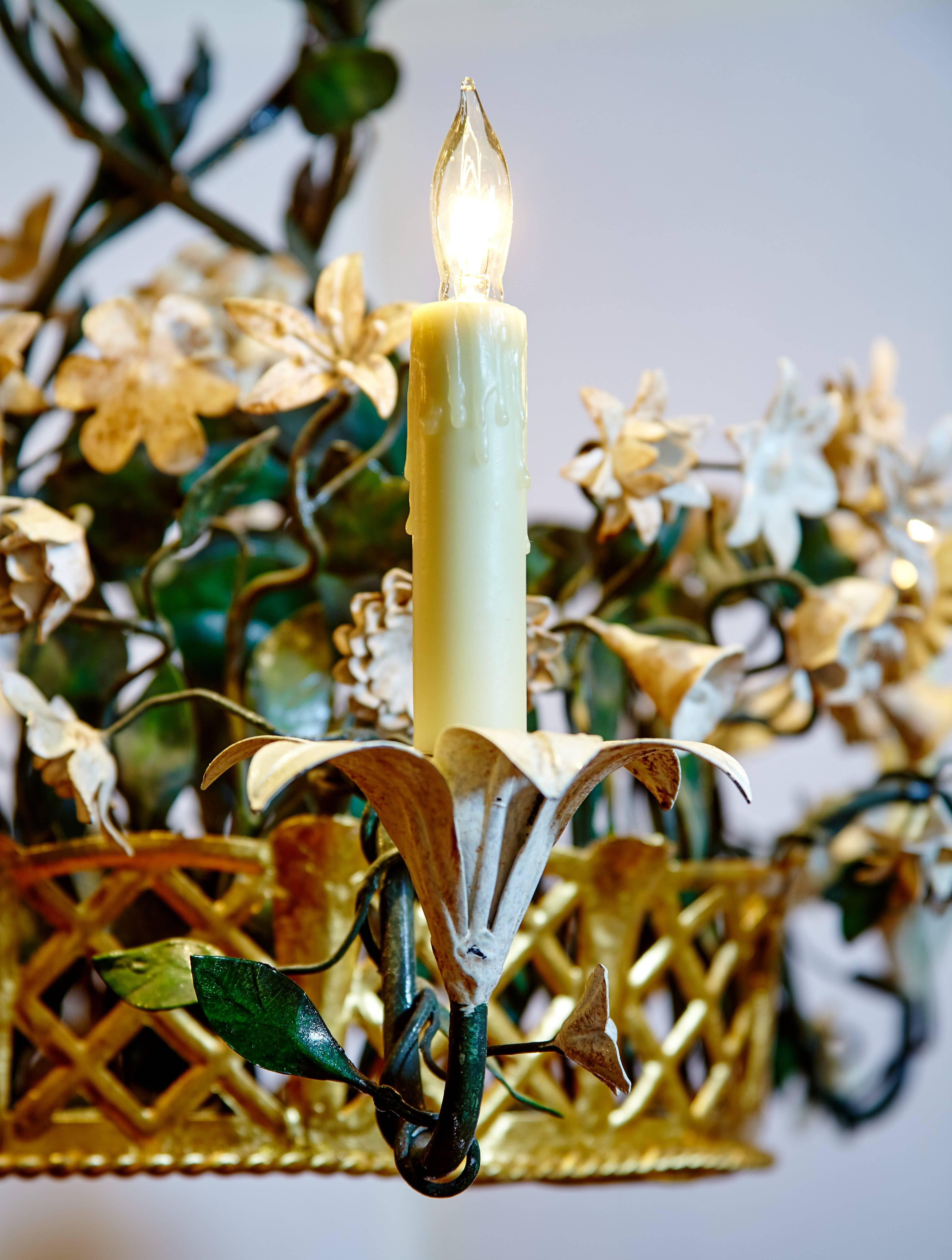 Elegant tole chandelier with antiqued white metal flowers and antiqued green foliage in a reticulated gilt metal basket. Six antiqued white lilies serve as candleholders that are wired for electricity.