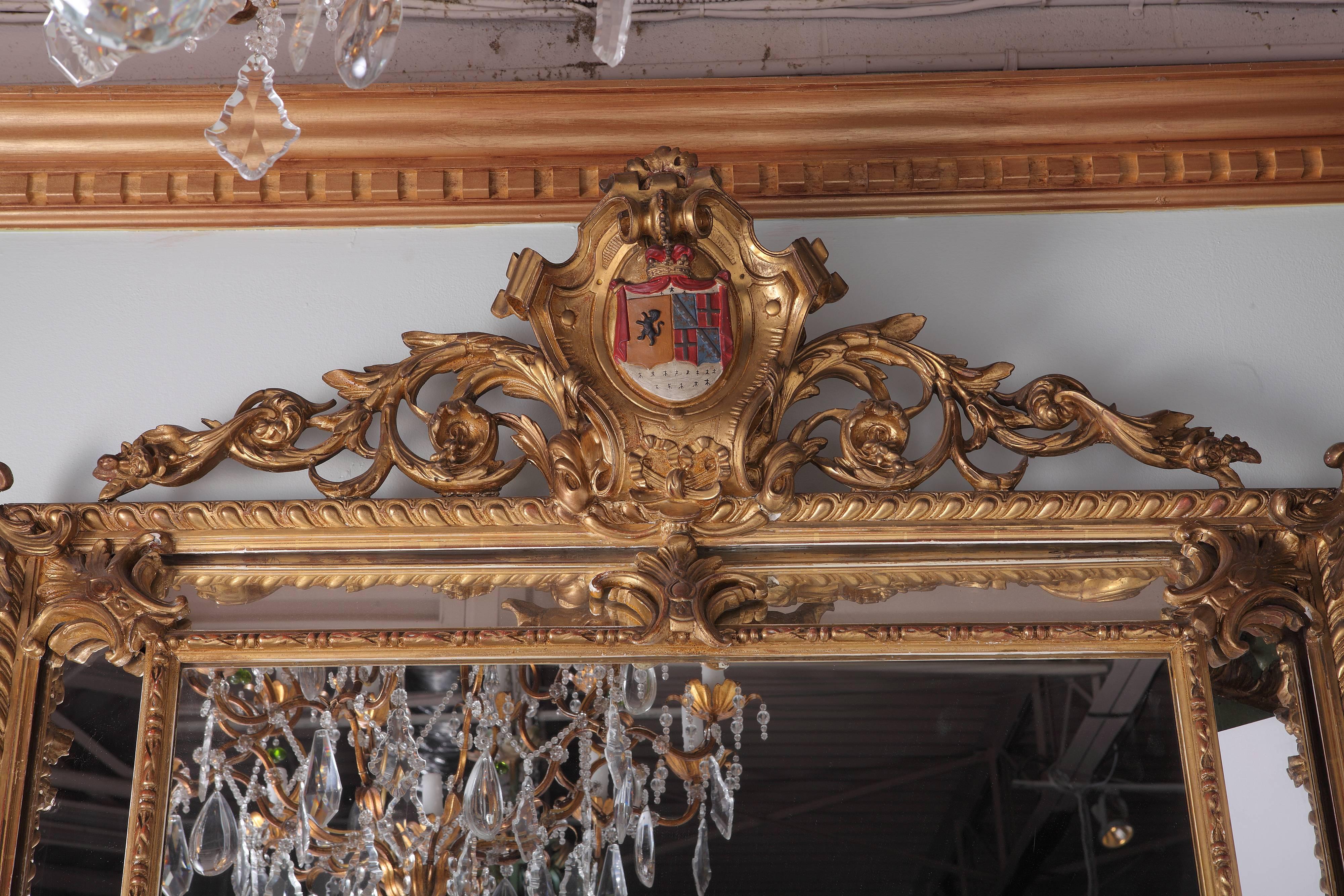 Late 19th century French gilt overmantle mirror. Cushion mirror has family crest centered in cartouche.