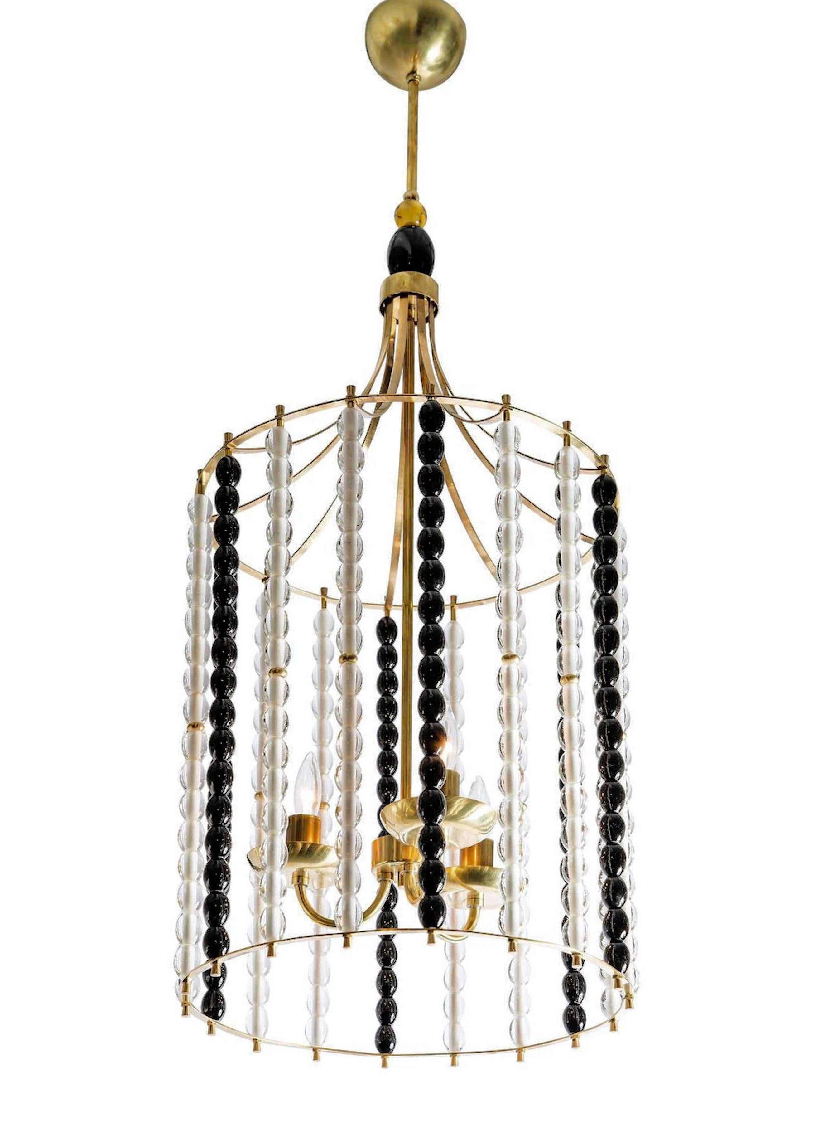 Pair of Mid-Century Murano bird cage lantern chandeliers with stacked black and clear Murano glass beads. Attributed to A. Barbini, circa 1960. Also available individually.